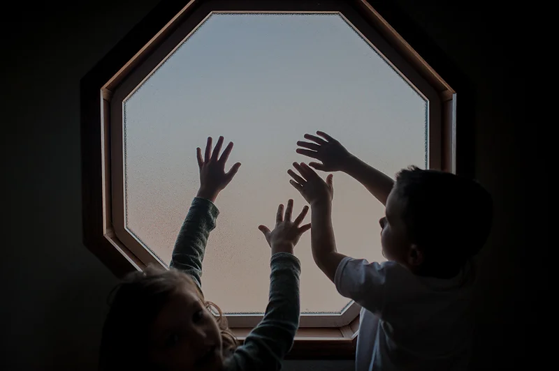Little kids hands playing in window