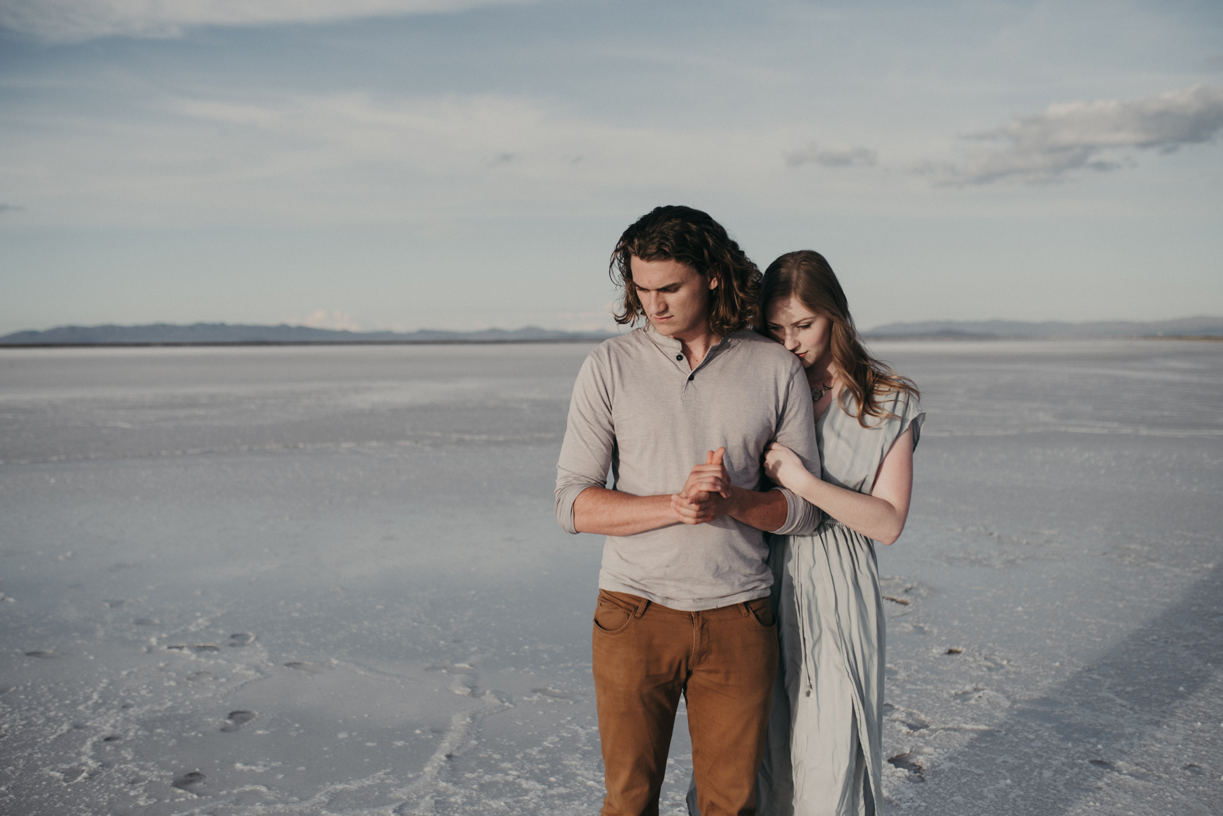 Girl hugging boy from behind on the salt flats