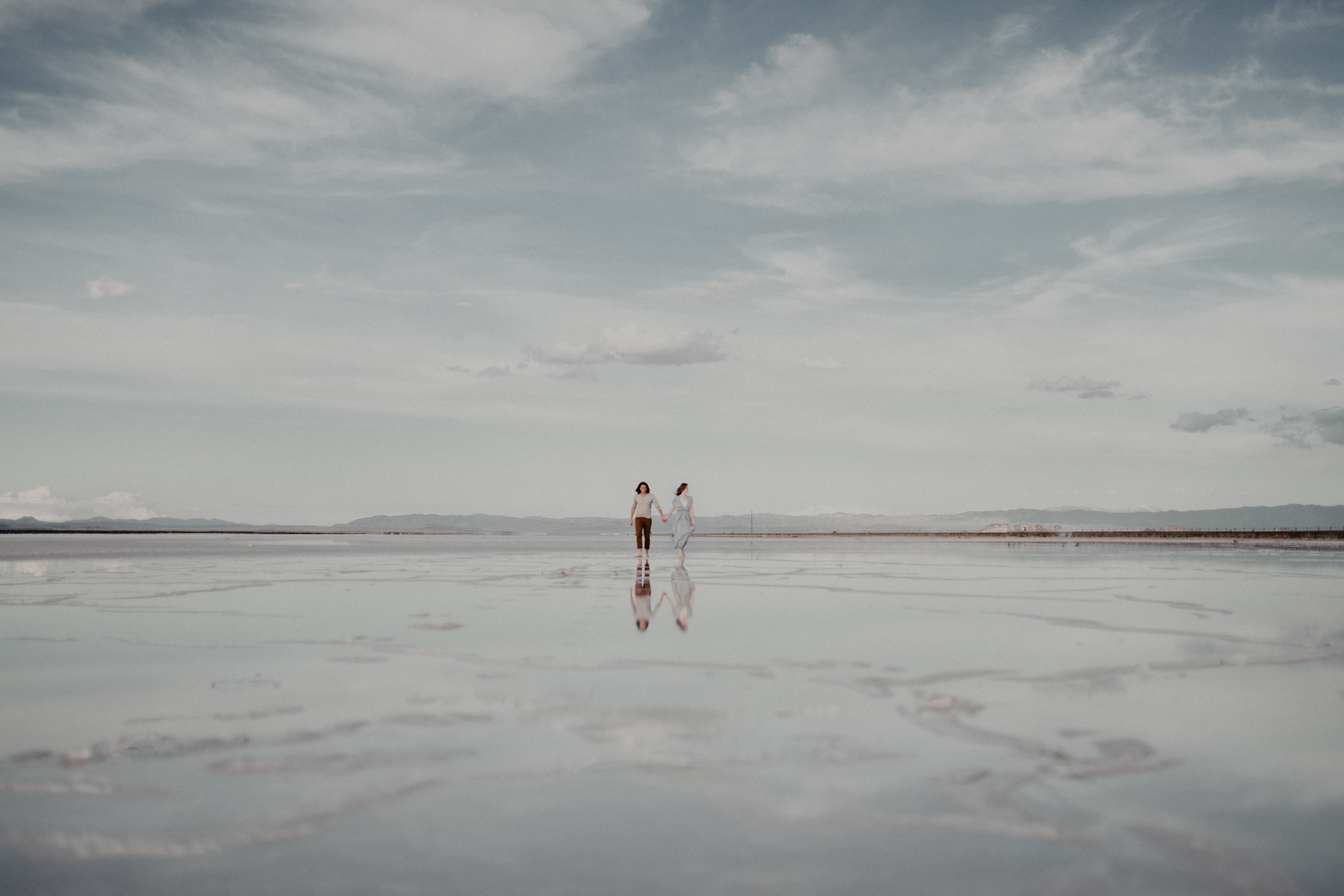 Couple standing on salt flats holding hands