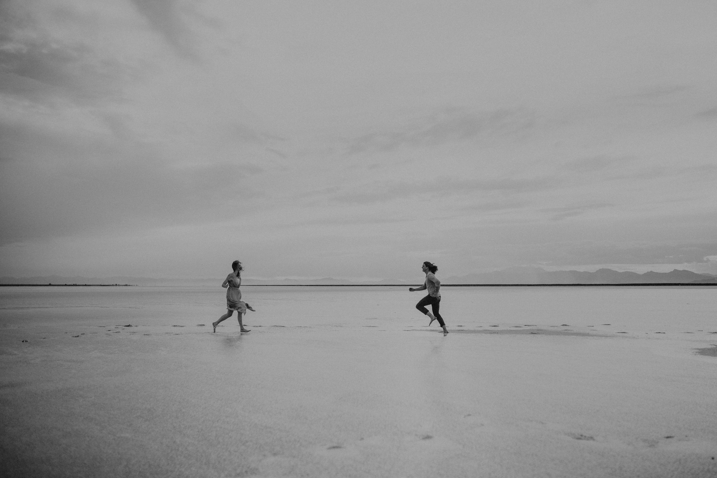 Couple running together on water and salt flats