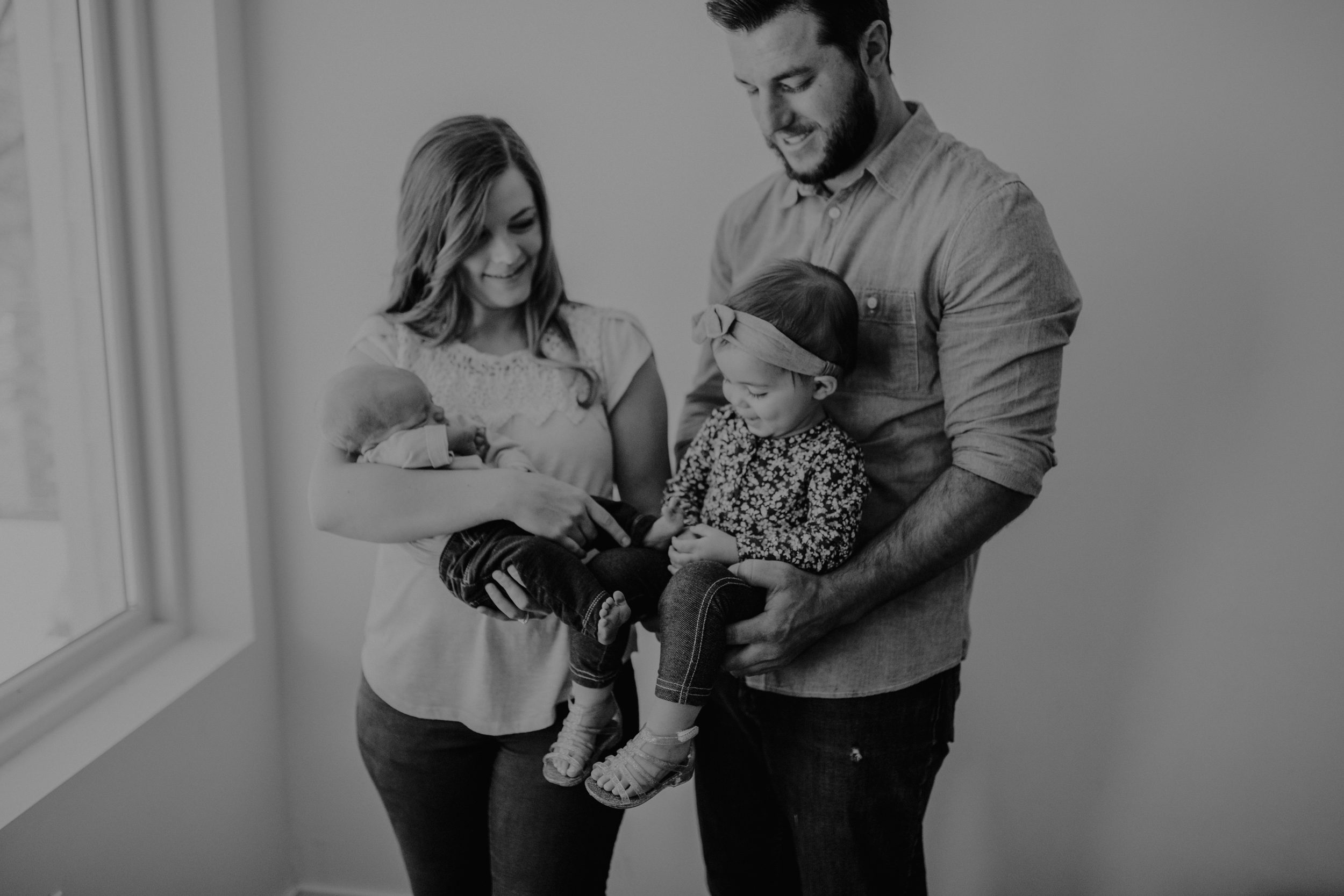 Mom and dad holding toddler girl and baby boy