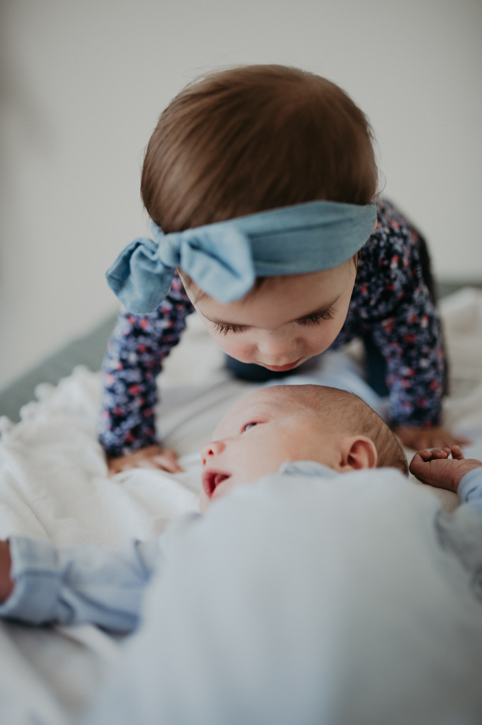 Toddler girl kissing baby brother