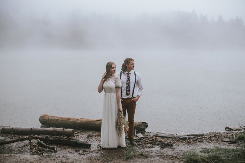 Couple in front of foggy lake while raining