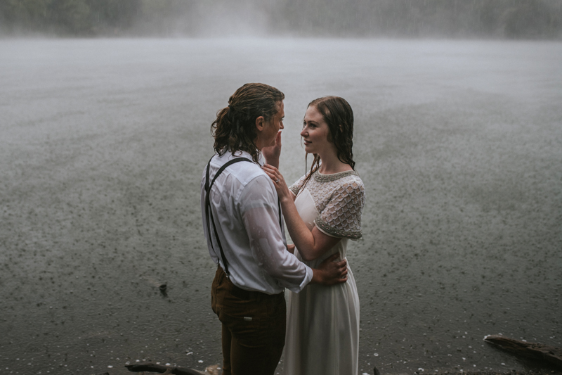 Couple in front of foggy lake in the rain