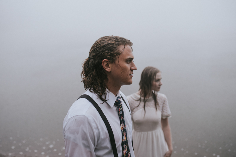 Couple in front of foggy lake in rain