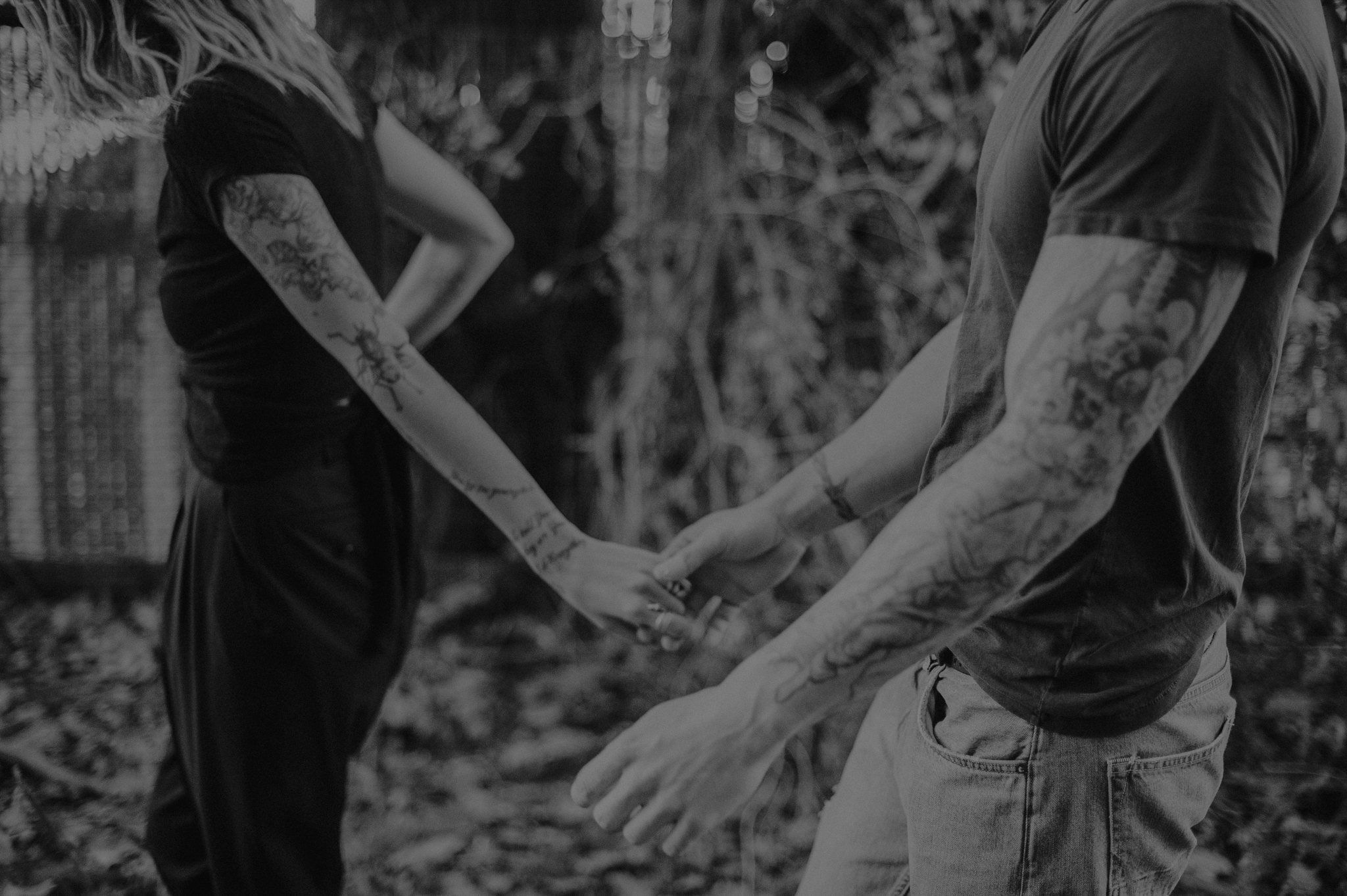 Tattooed couple holding hands walking outside