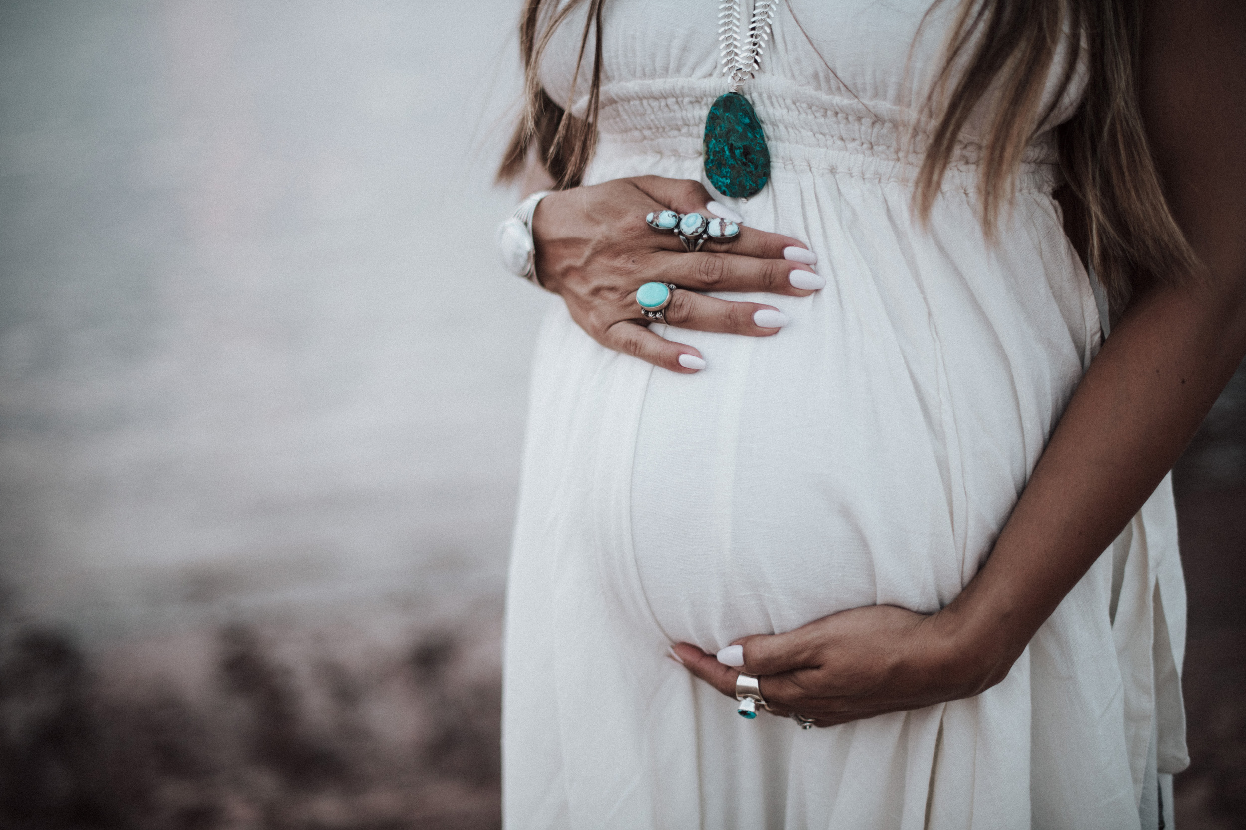 pregnant mom wearing turquoise rings and necklace