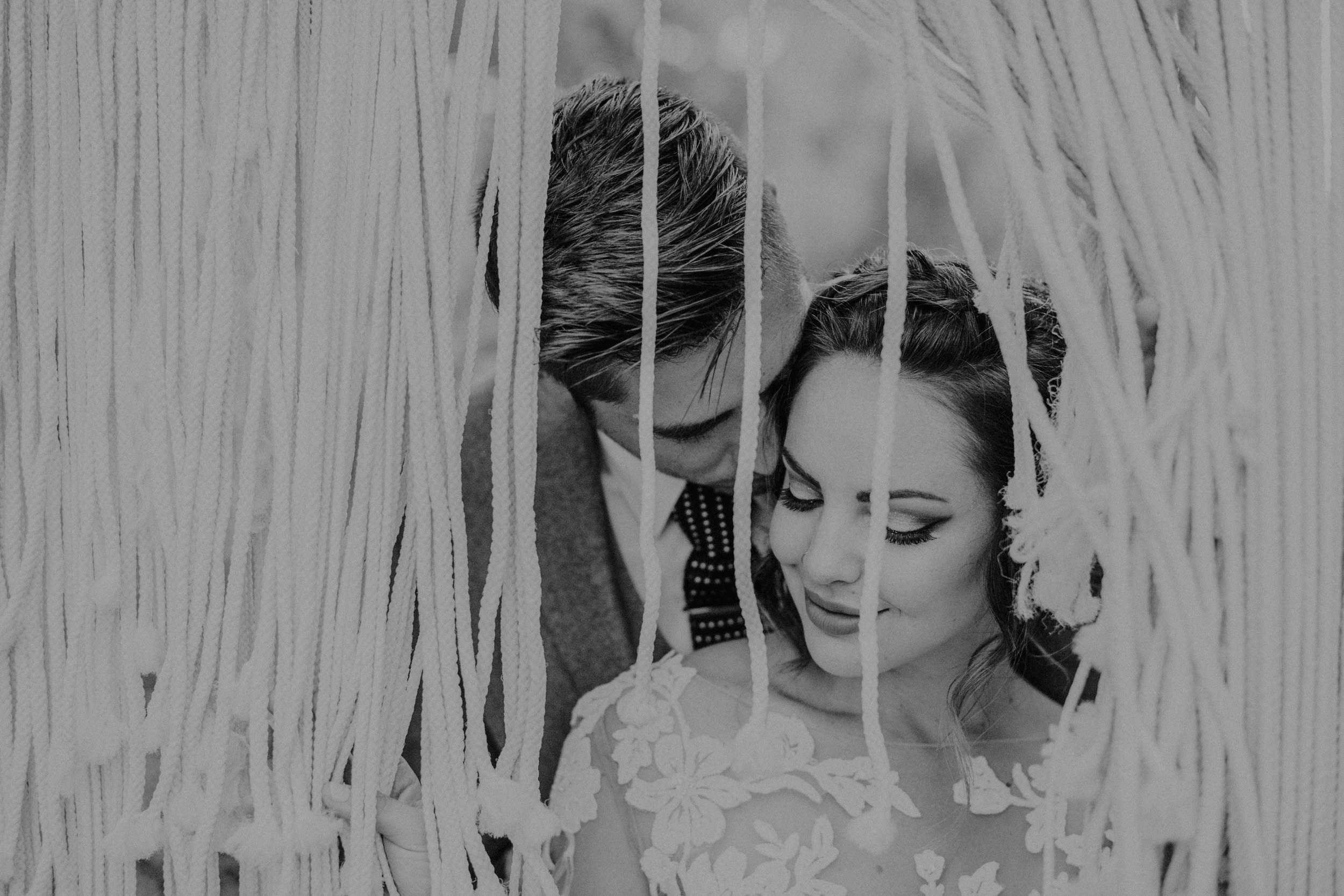 Bride and groom in front of boho Macrame