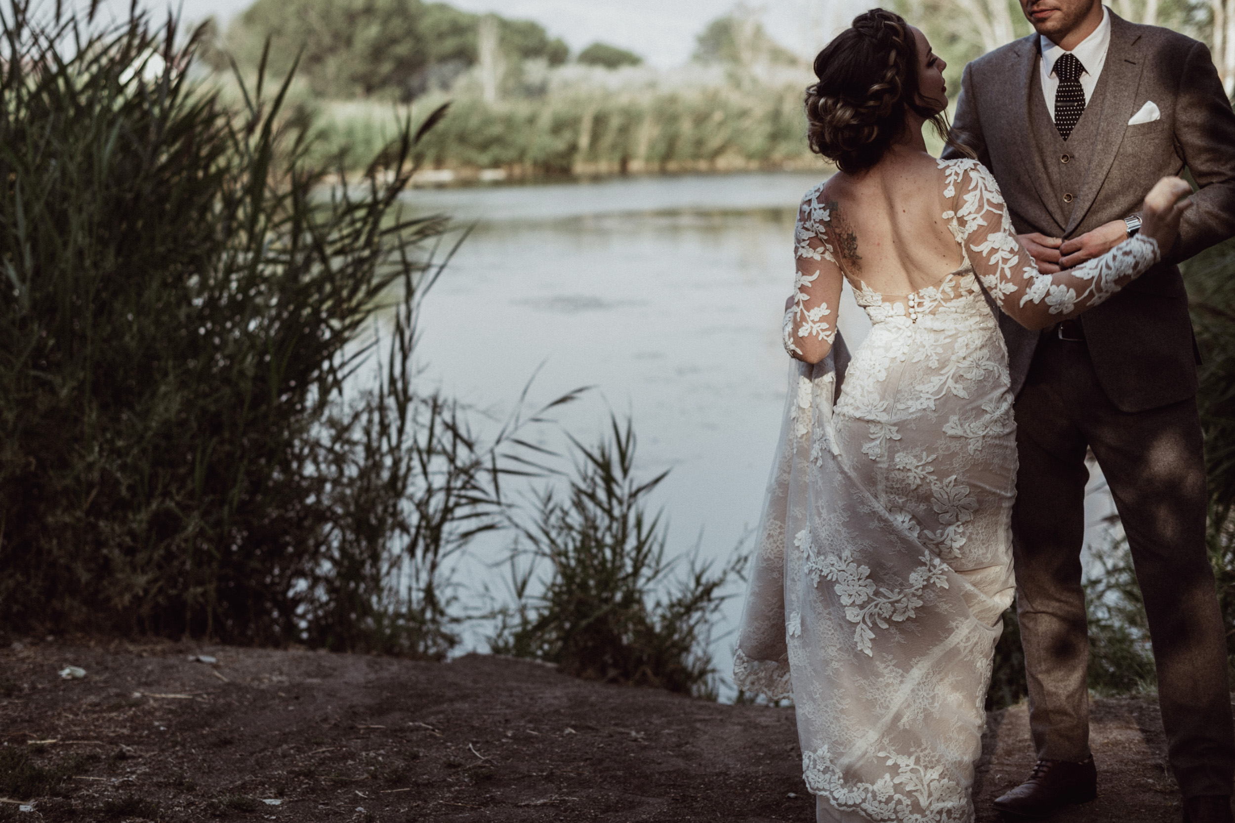 Bride and groom holding hands at loch lomond pond