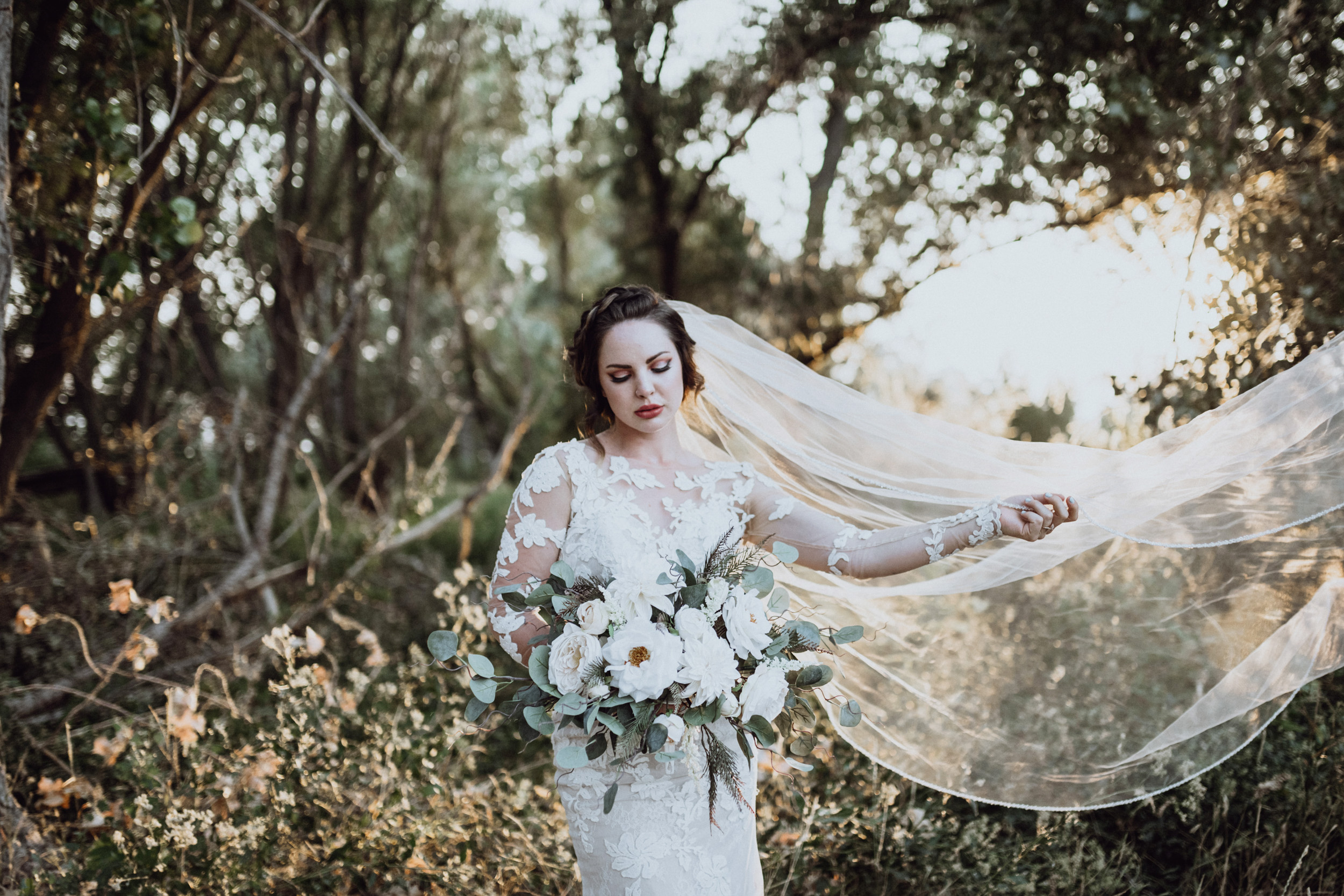 Bride holding bouquet in grassy field 