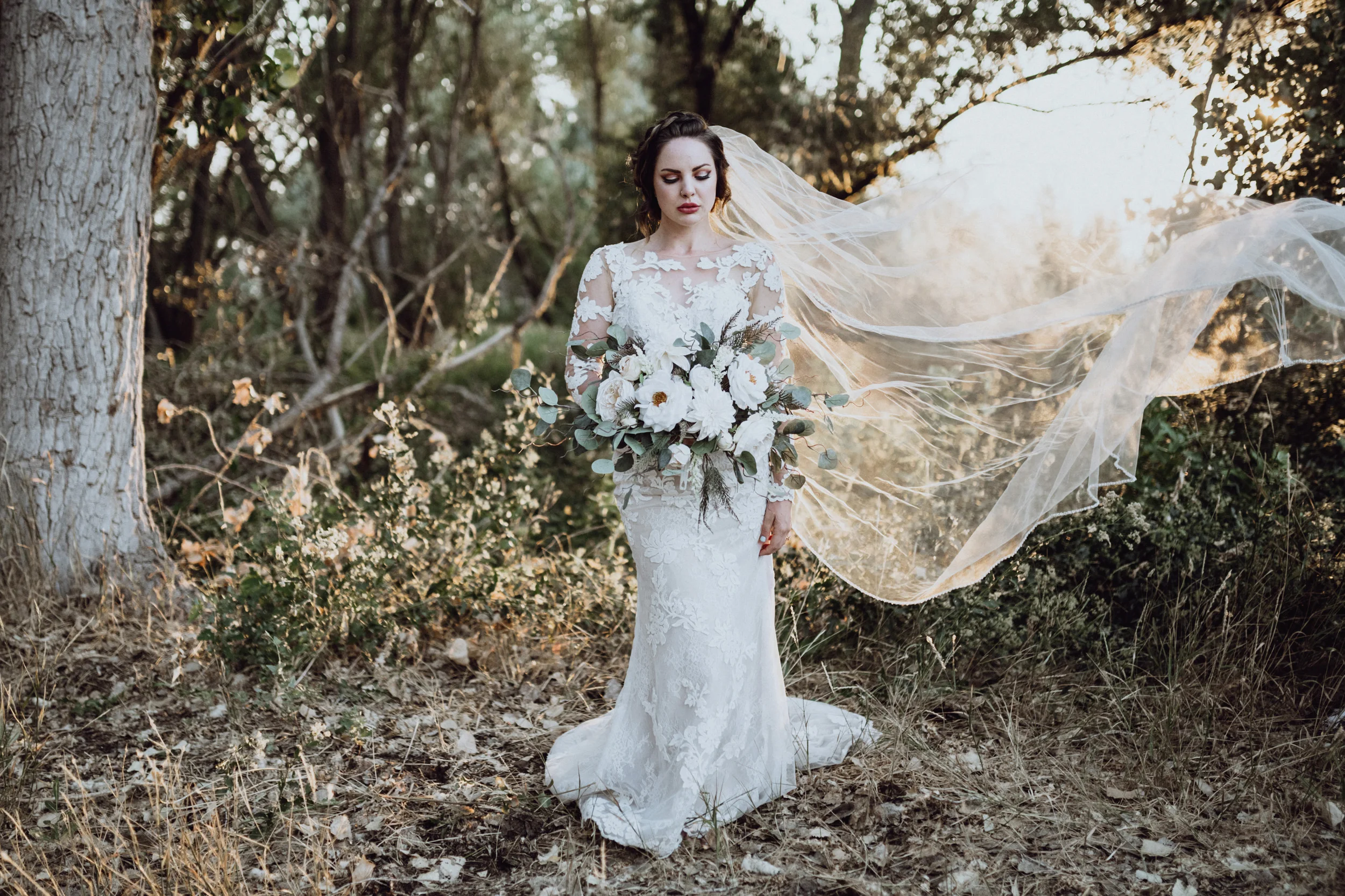 Bride holding bouquet in grassy field