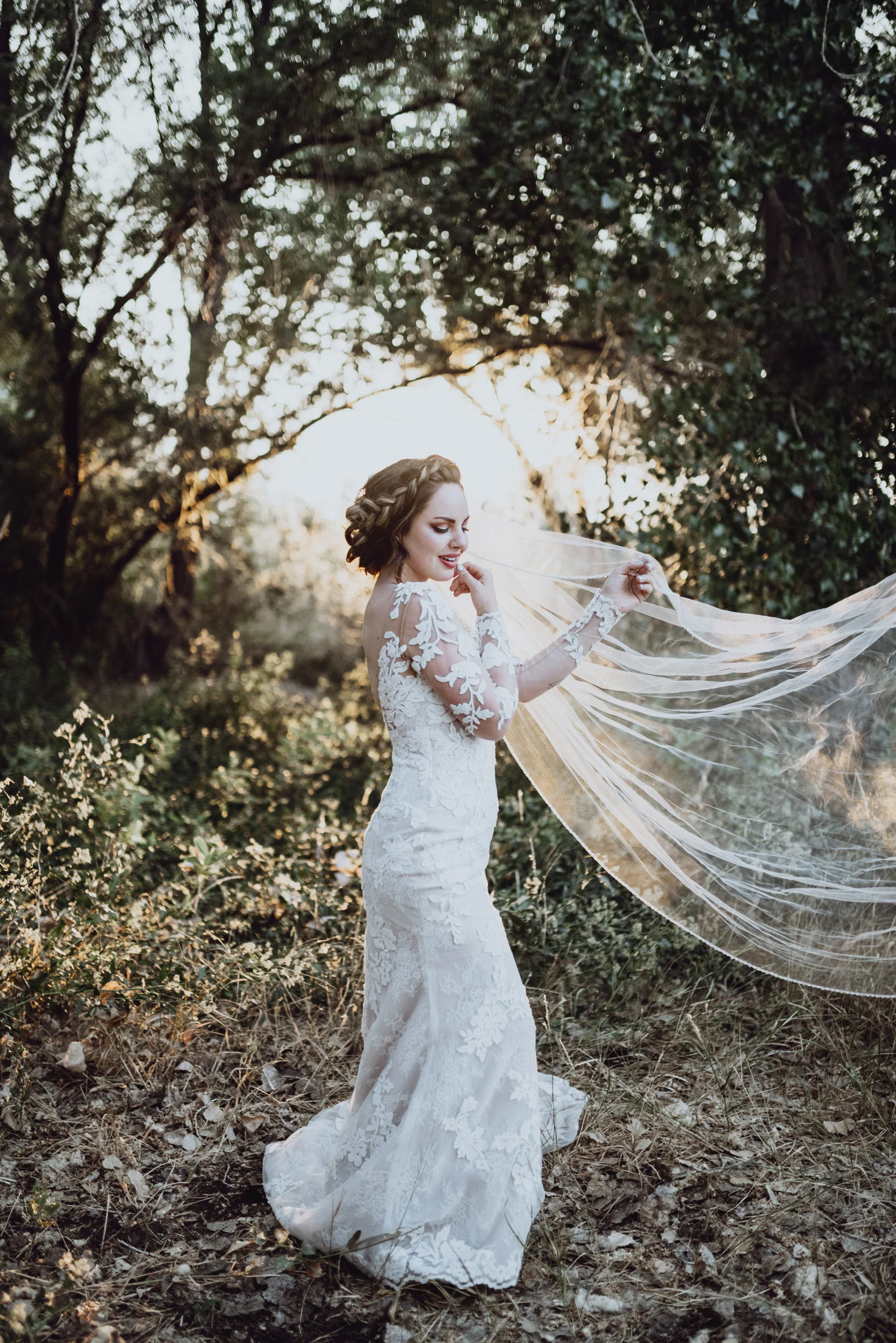Bride in lace dress standing in grassy field