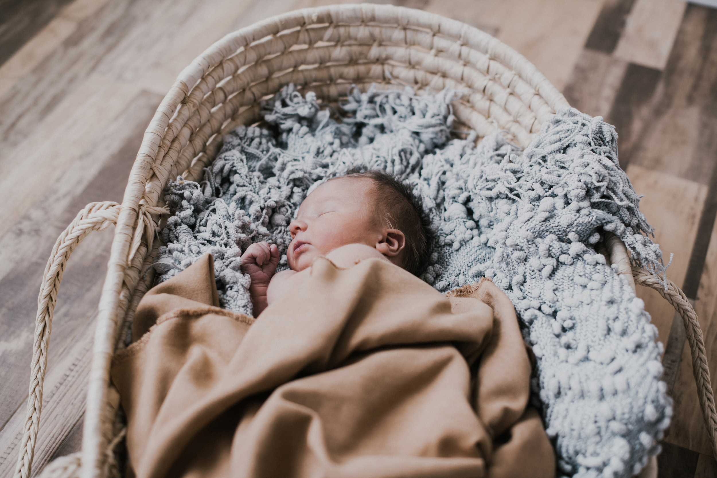 newborn baby boy sleeping in moses basket