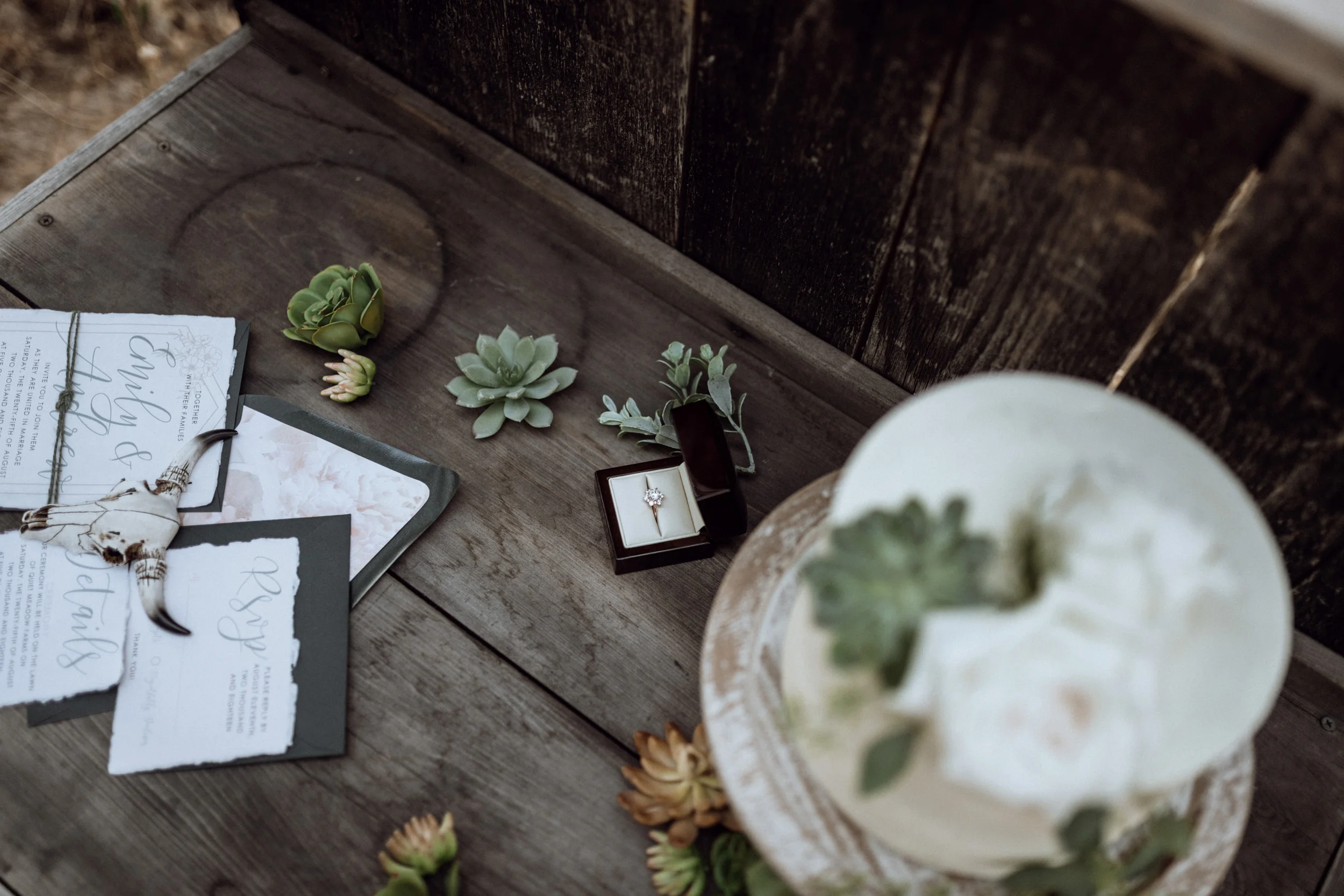 wedding stationary and cake on rustic wooden table