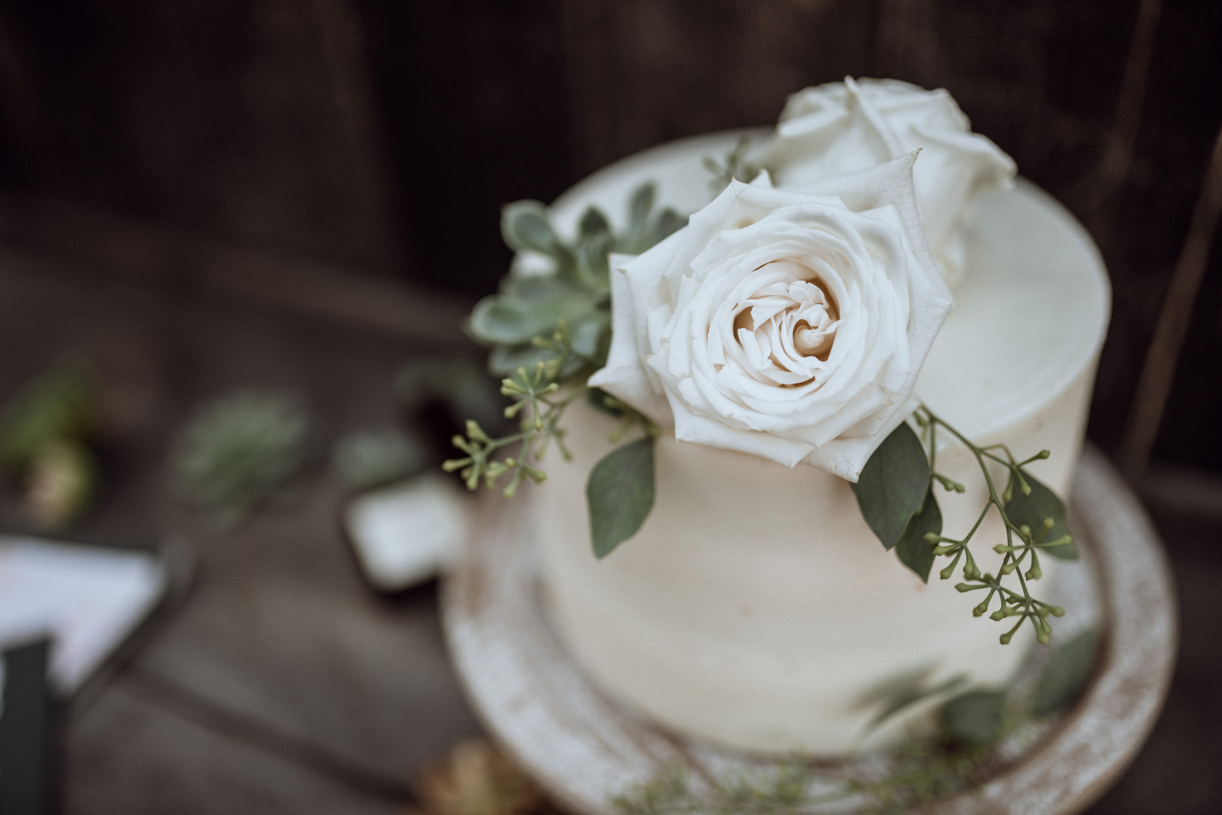 cream wedding cake with flowers and eucalyptus