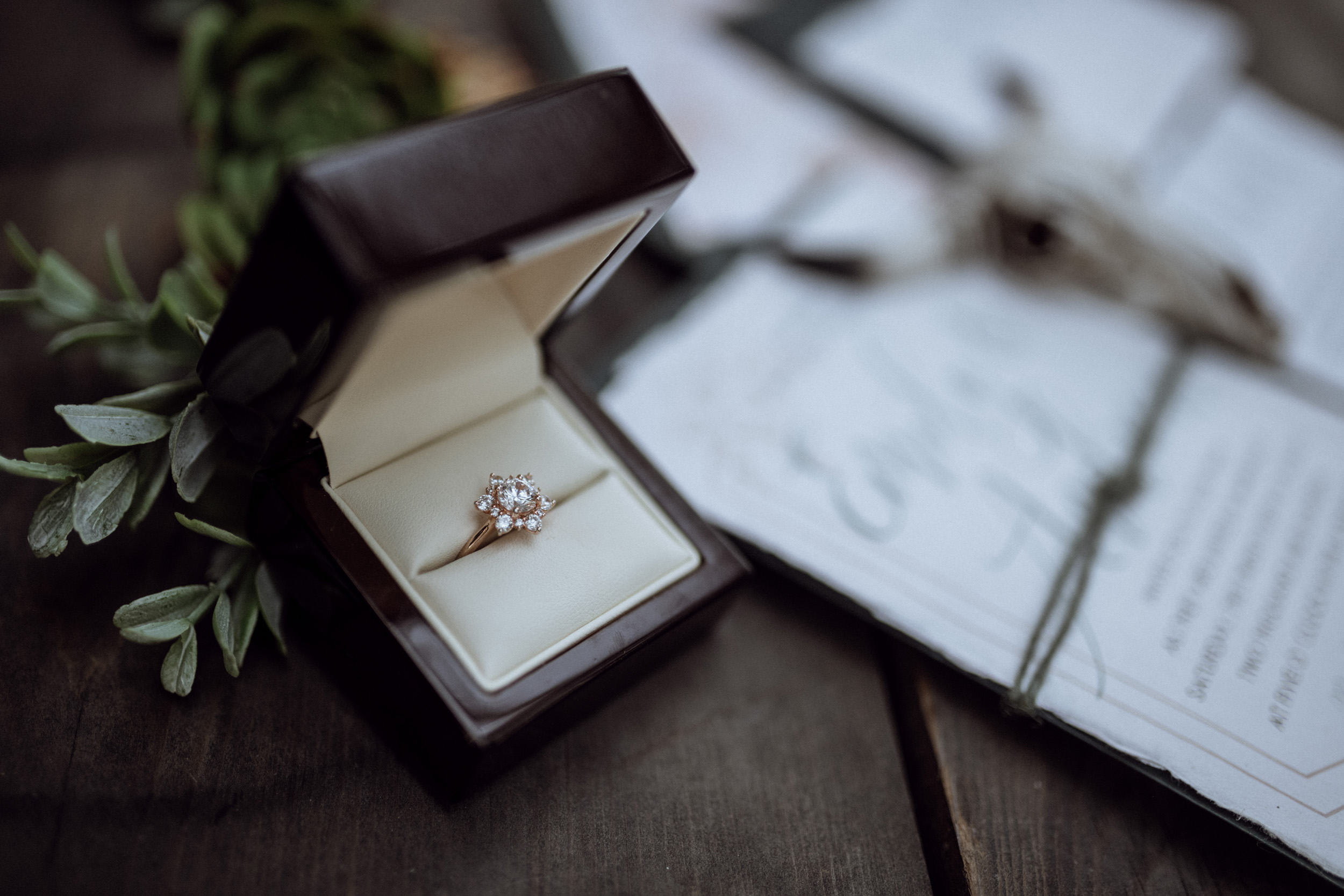 rose gold wedding ring on wooden table with stationary