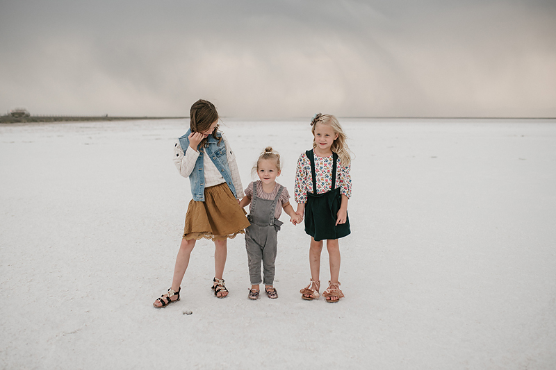 three sisters playing together on the salt flats