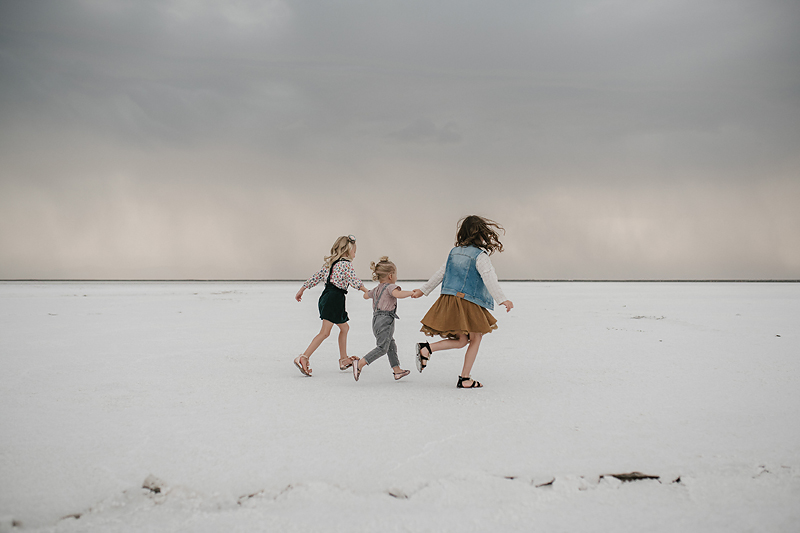 three little girls running on the bonneville salt flats