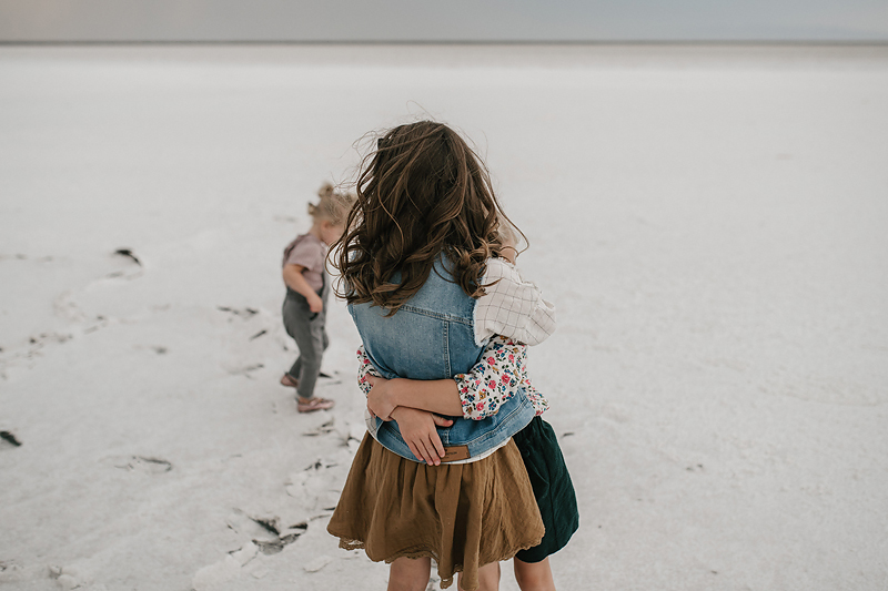 sisters in skirts hugging on the salt flats