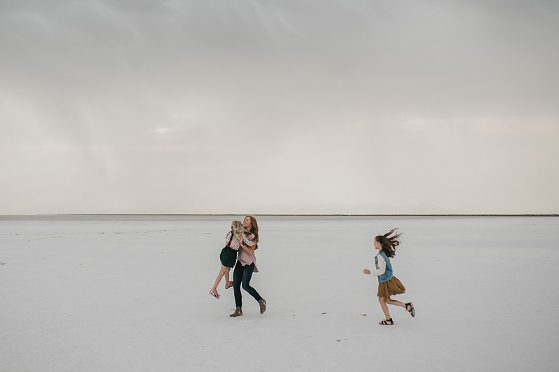 little girls running to mom playing on the salt flats