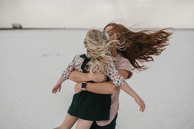 red head mom swinging little girl around