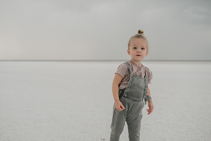 toddler girl in overalls on the bonneville salt flats