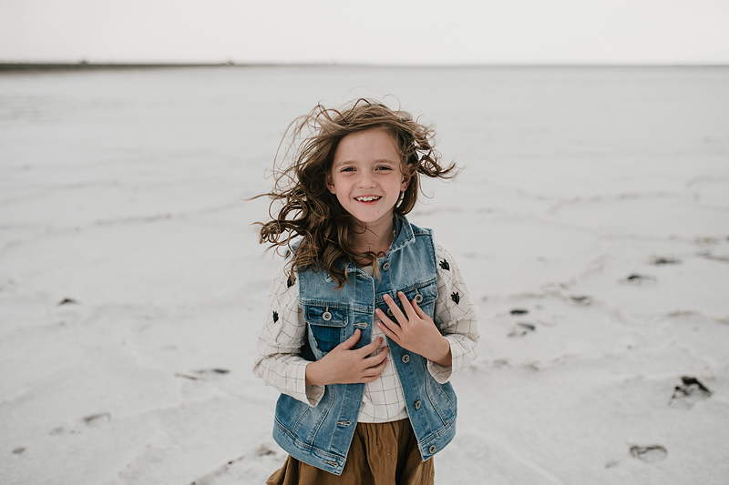 little girl smiling with wind blowing through her hair