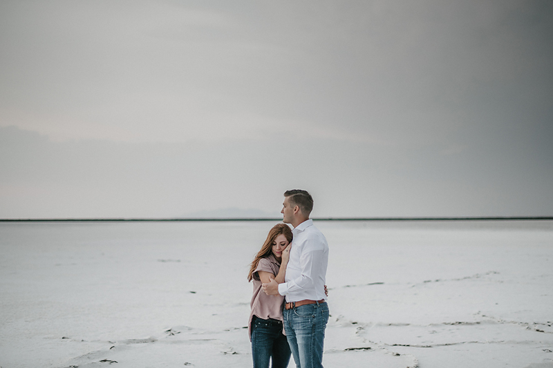 husband and wife hugging in evening light on salt flats