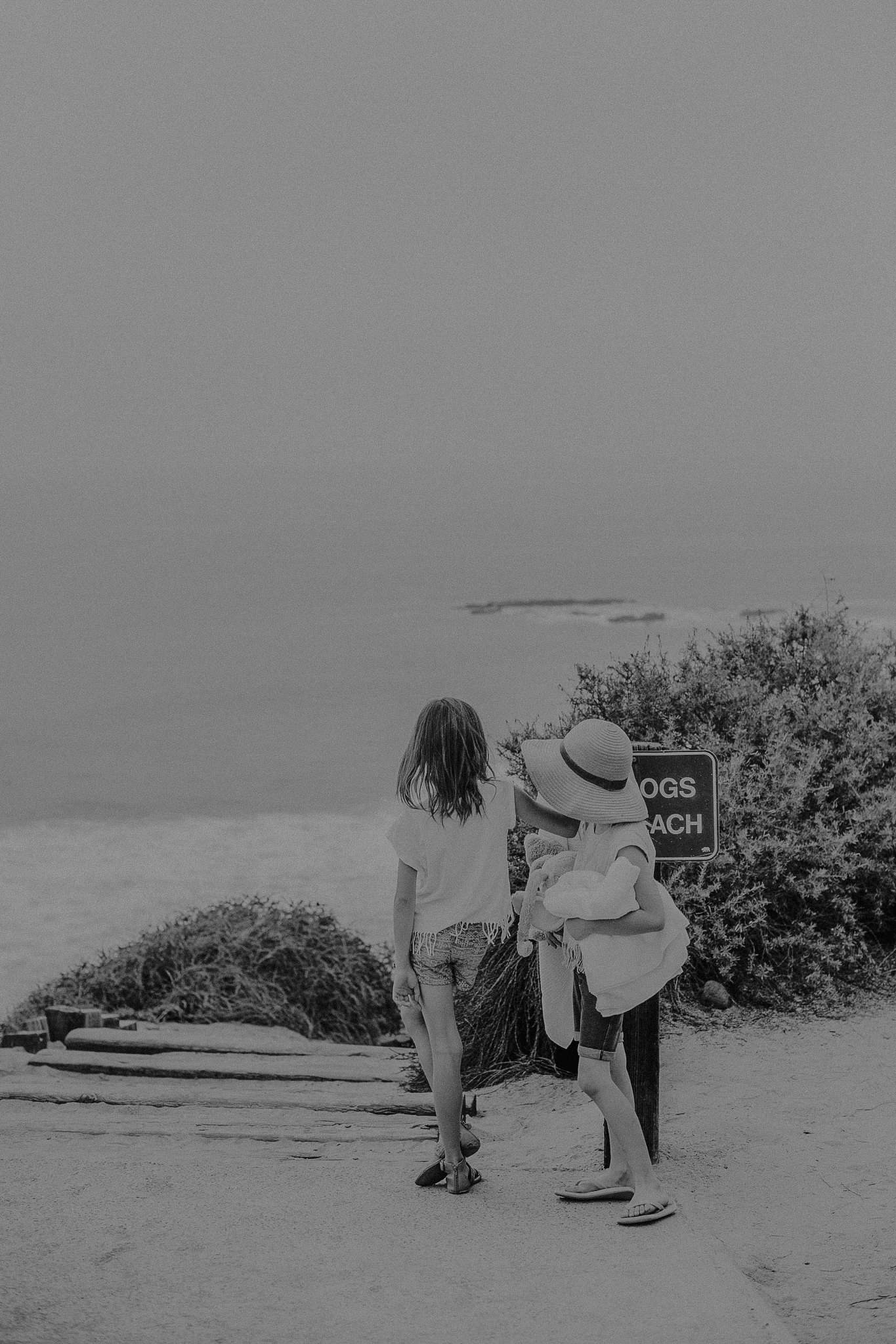 Two girls holding hands walking to the beach