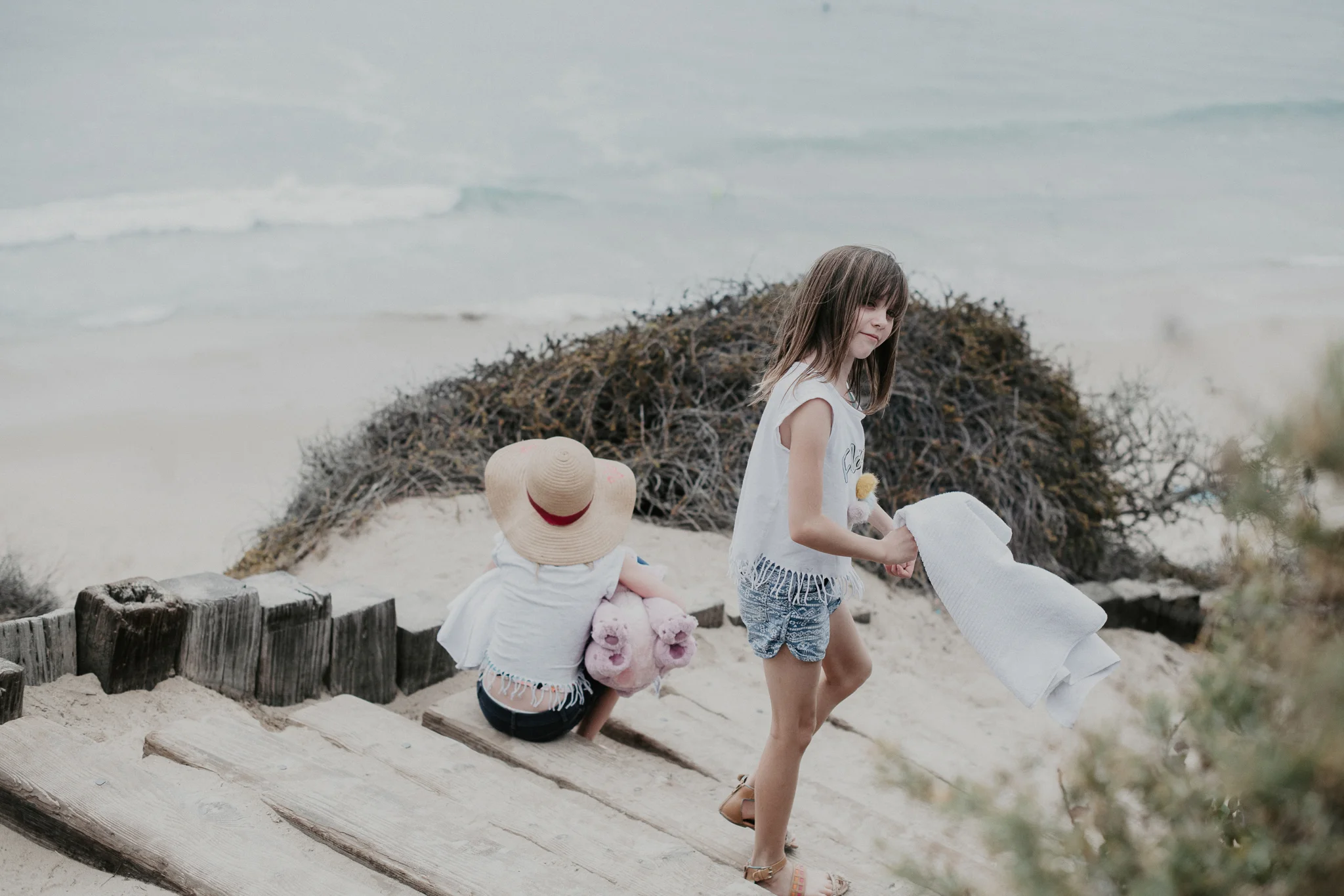 Little Girl with hat walking with sister to the beach
