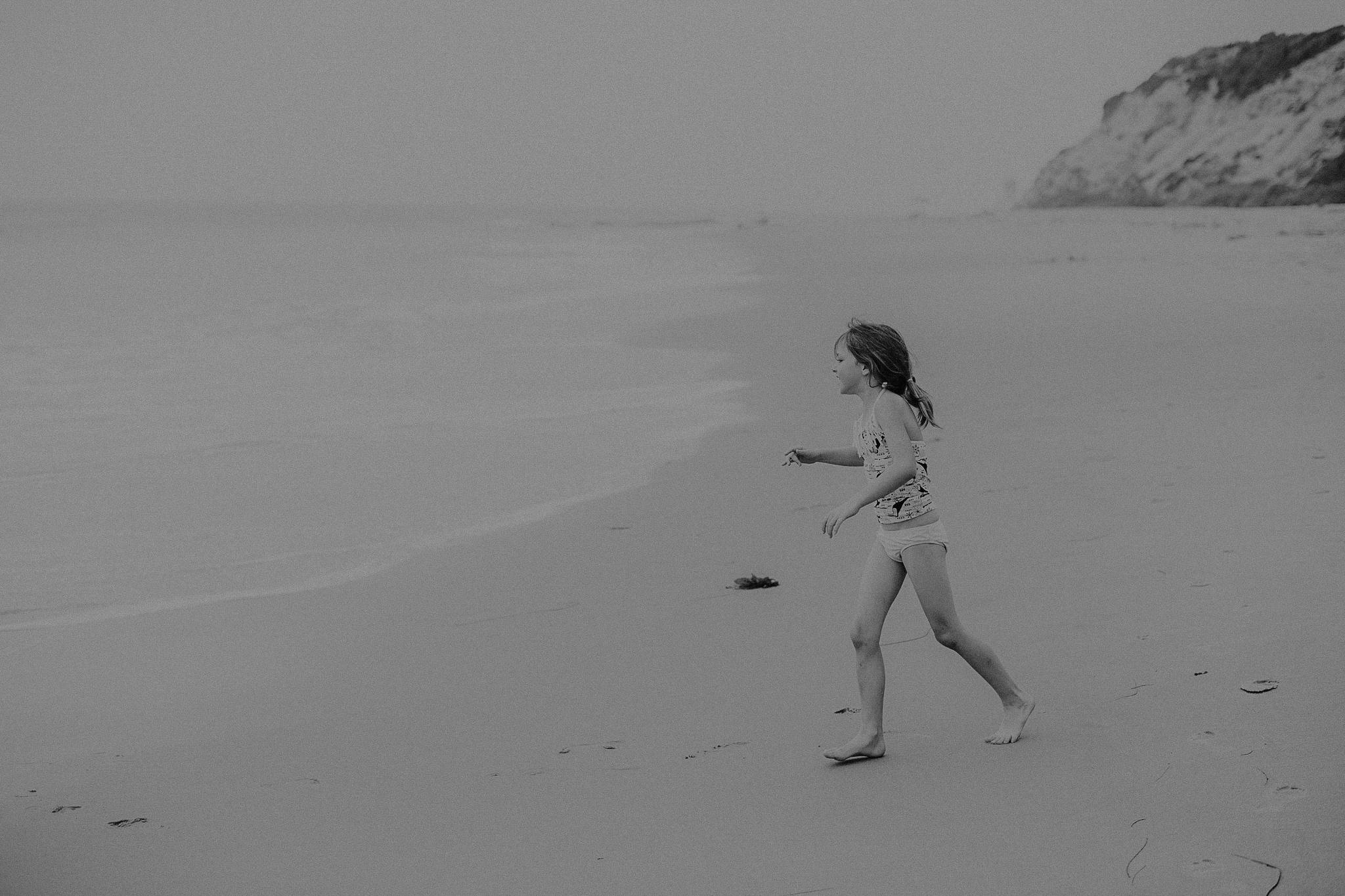 Little girl running towards the water