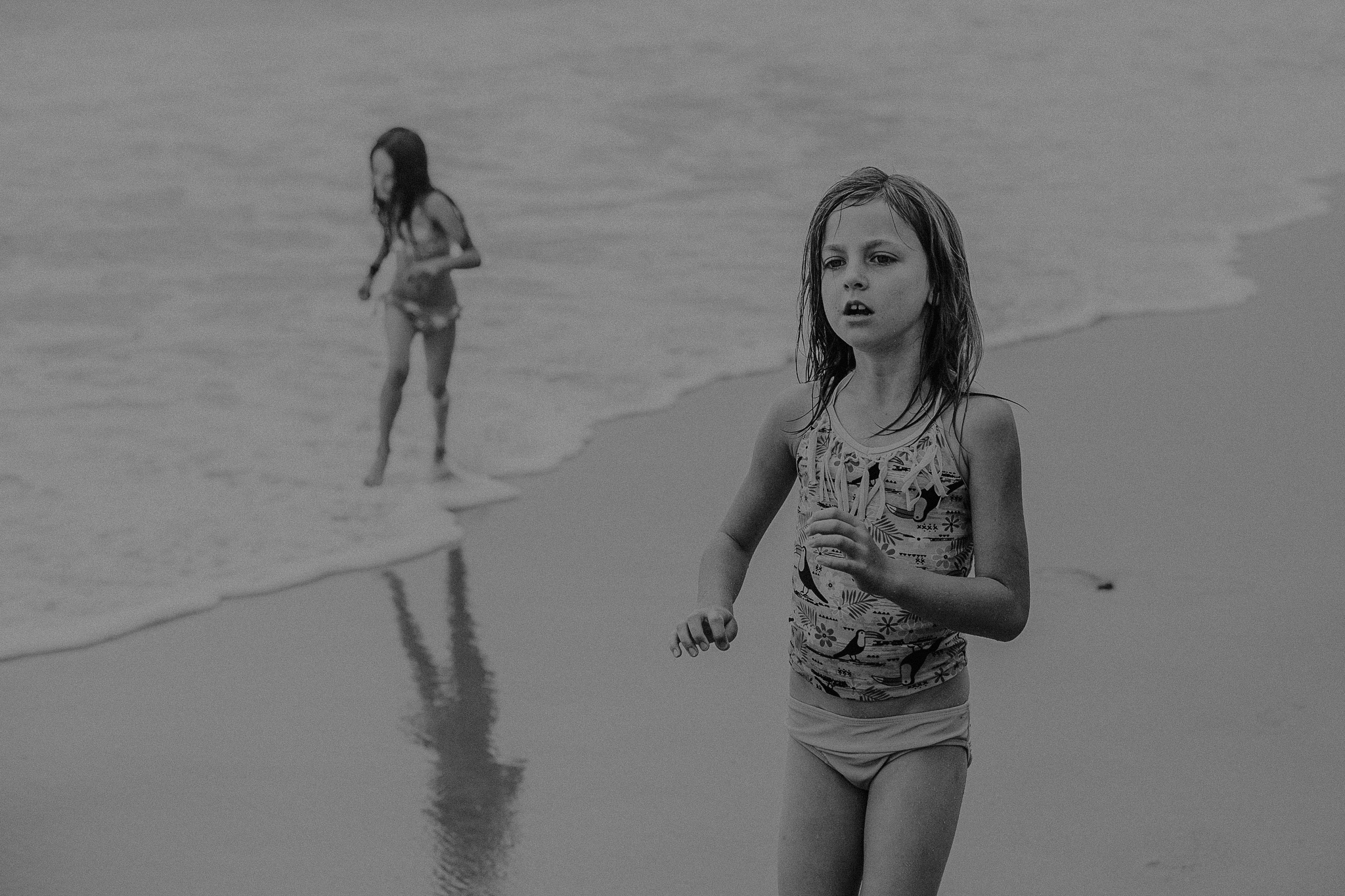 Young girls playing along the beach together