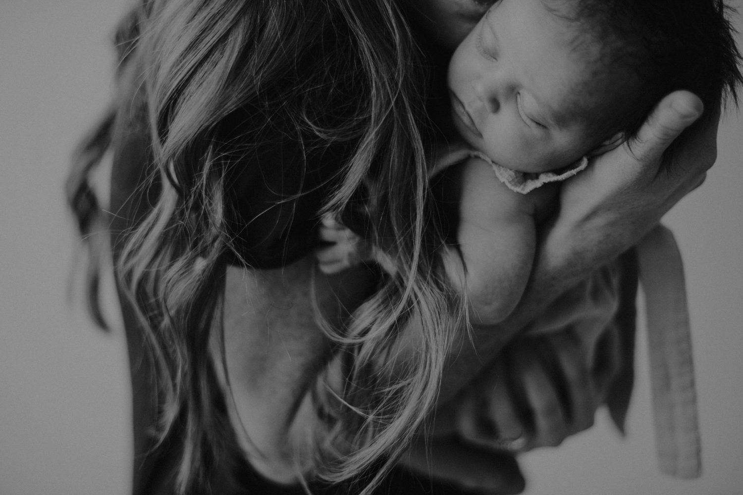 Newborn baby girl asleep in her moms arms