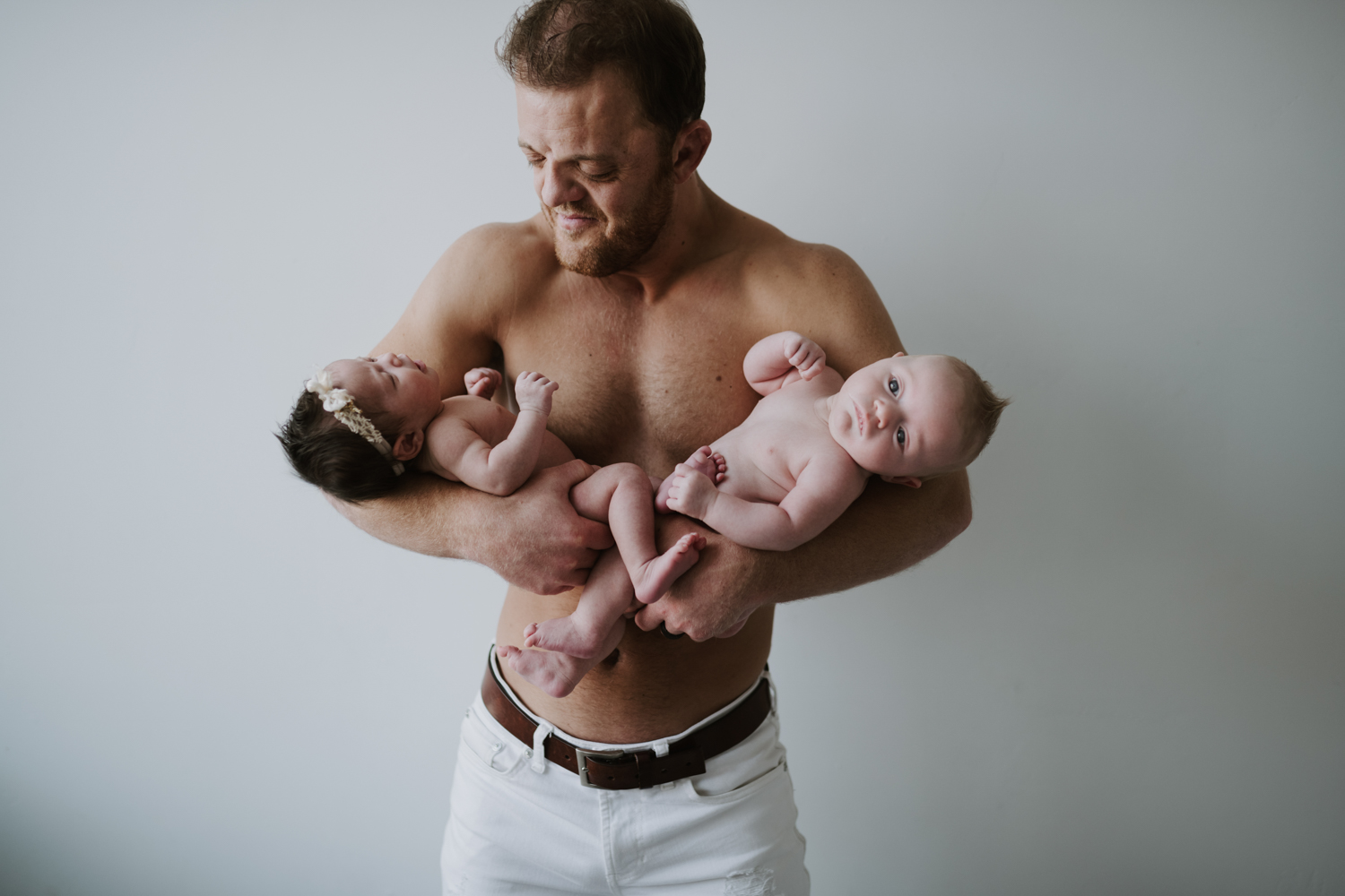 Dad holding both newborns