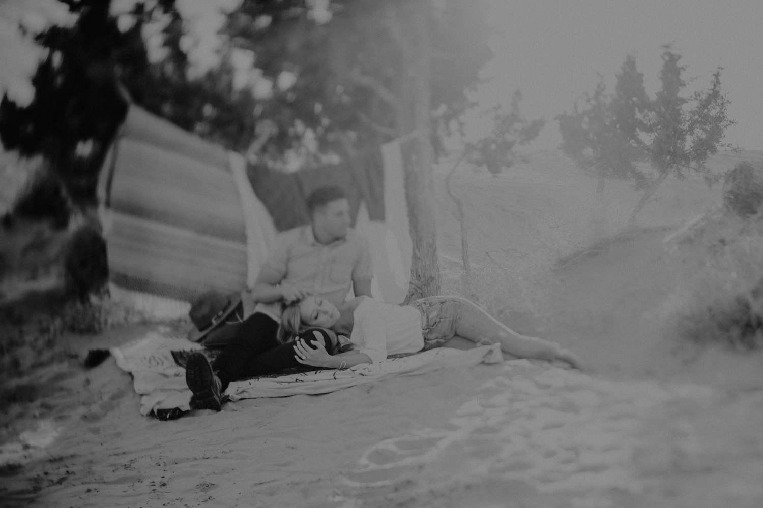 couple lying in the sand on rugs at utah sand dunes