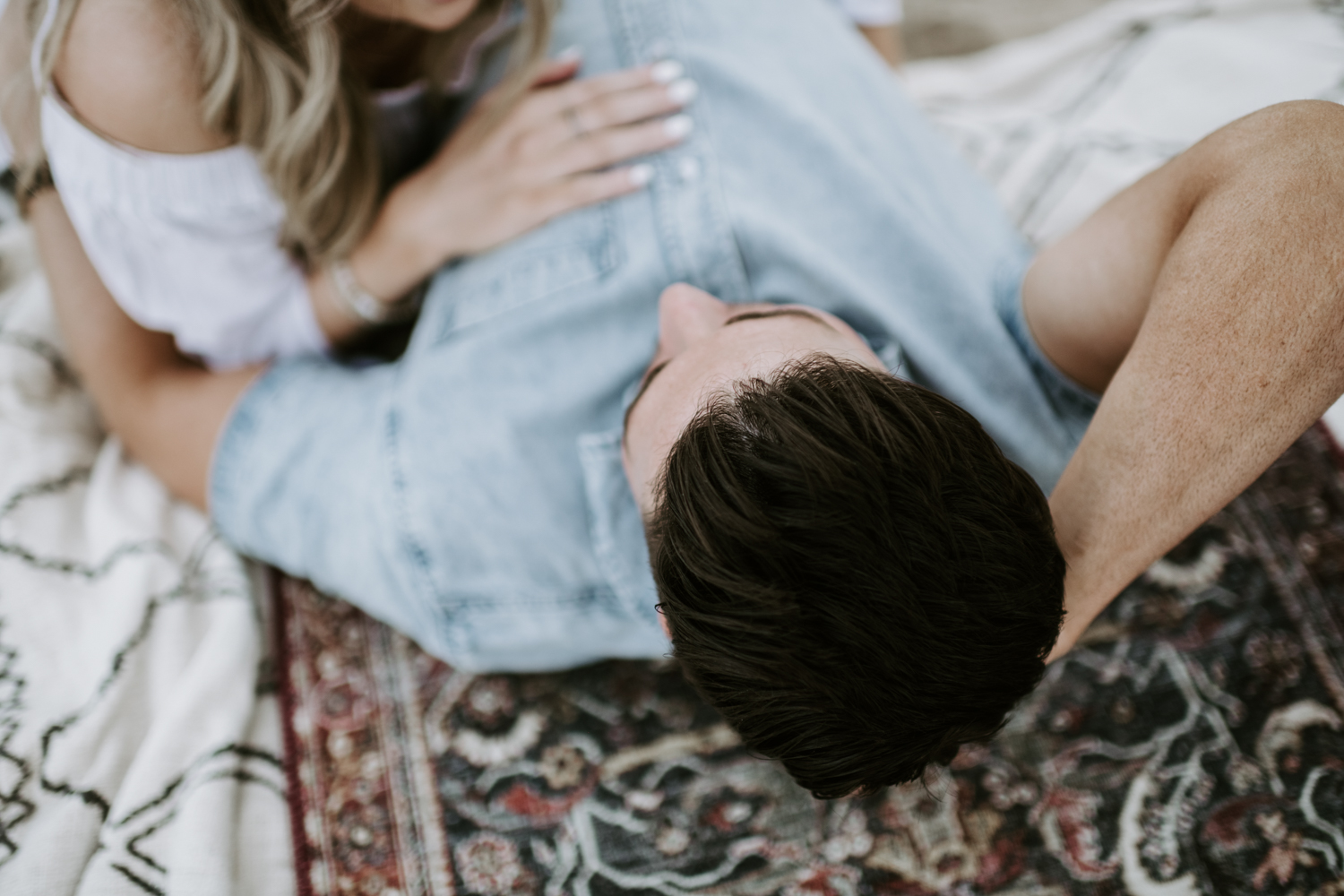 couple lying in the sand on rugs at utah sand dunes