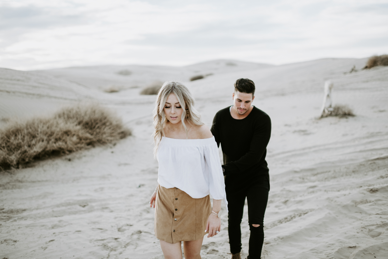 couple walking holding hands at utah sand dunes