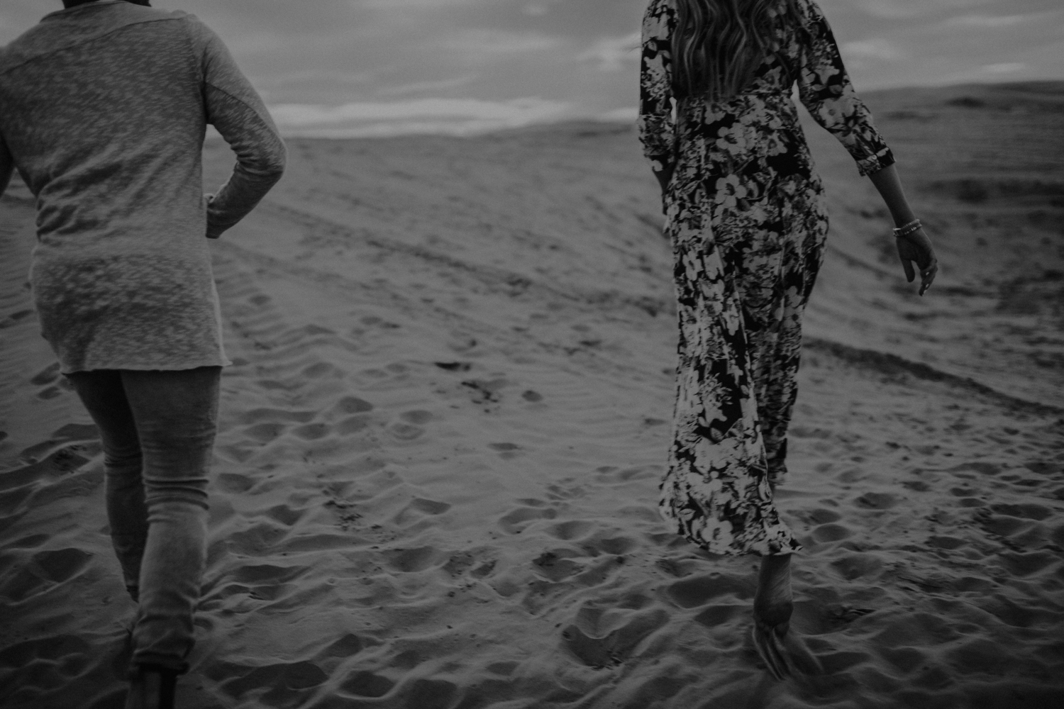 couple walking along sandy hills at utah sand dunes