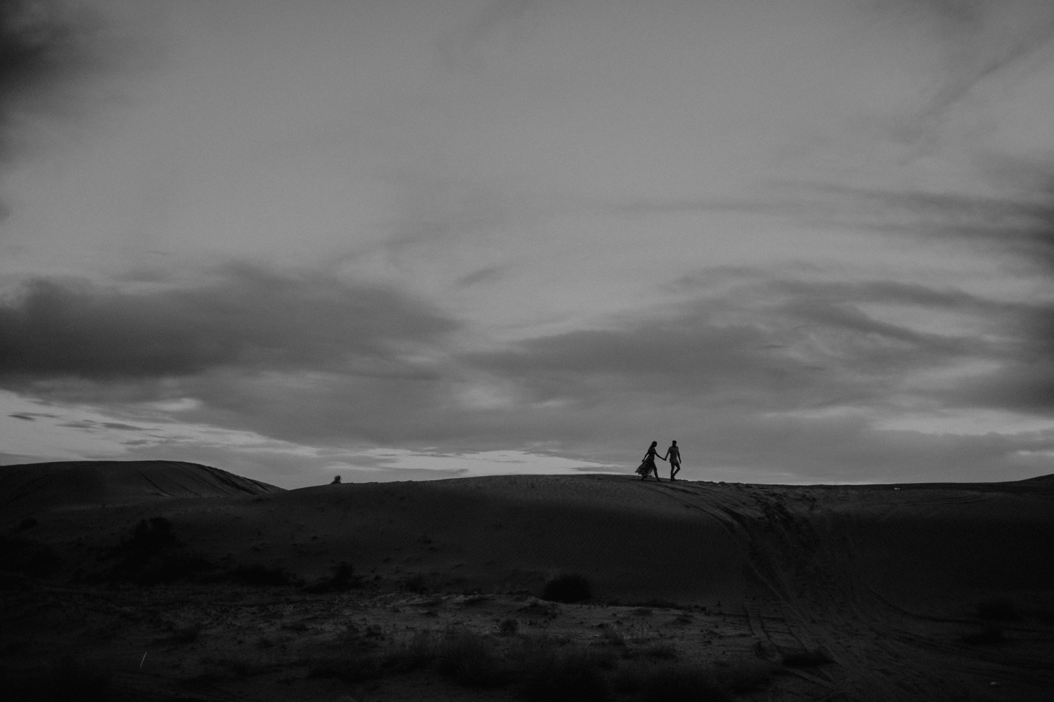 silhouette of couple on top of sand dunes in utah
