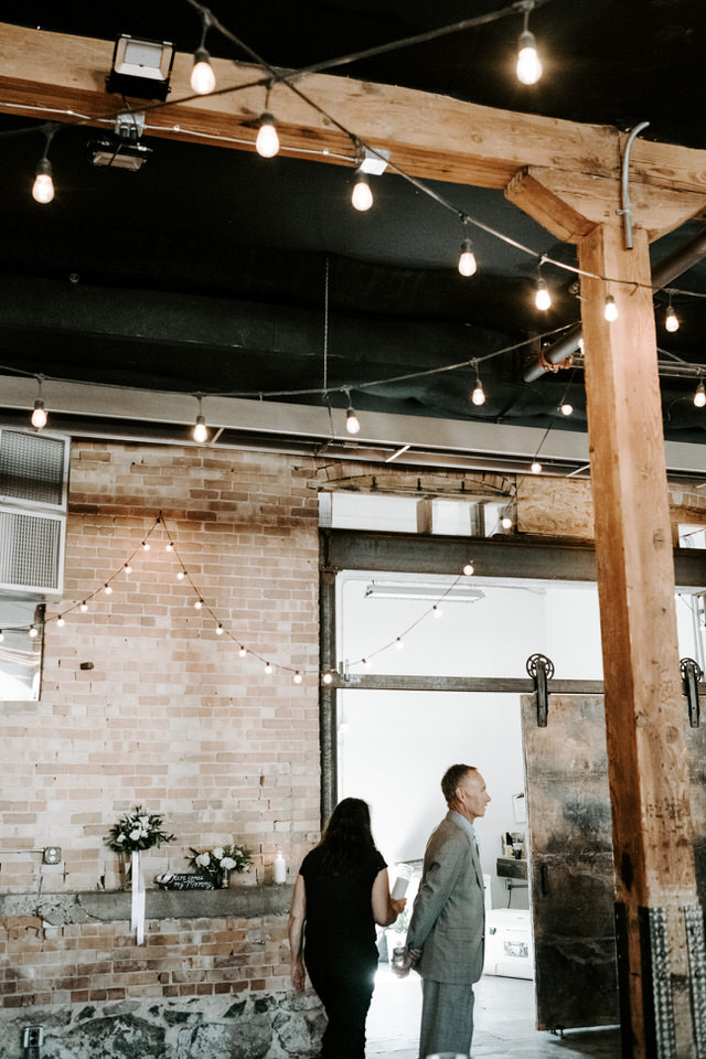 groom's dad standing in industrial wedding venue
