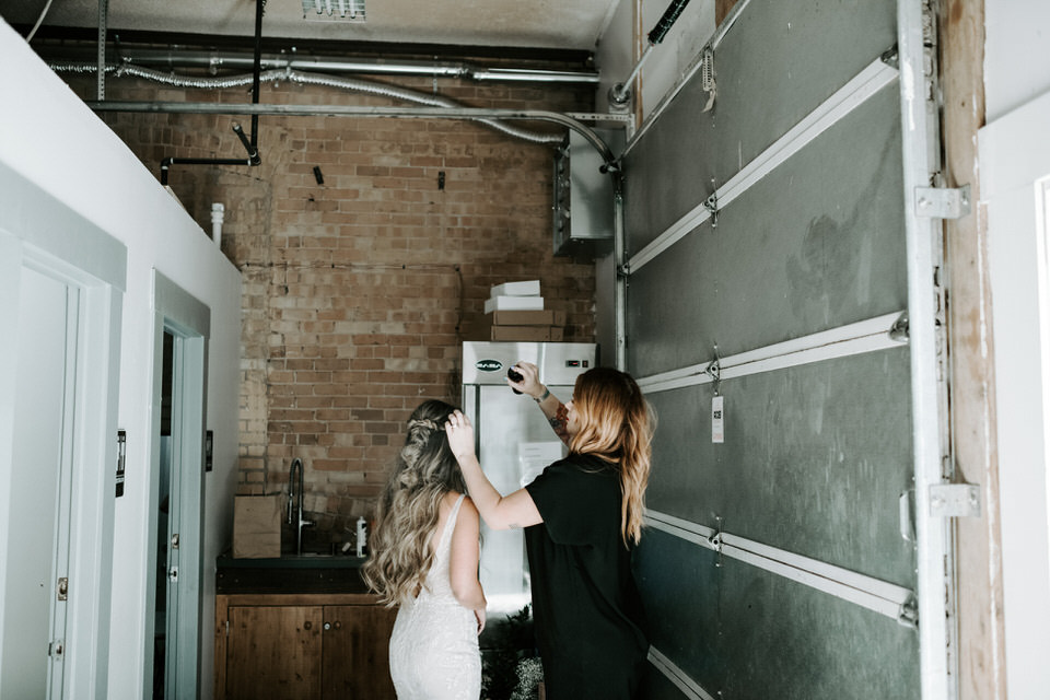 bride getting hair done at wedding