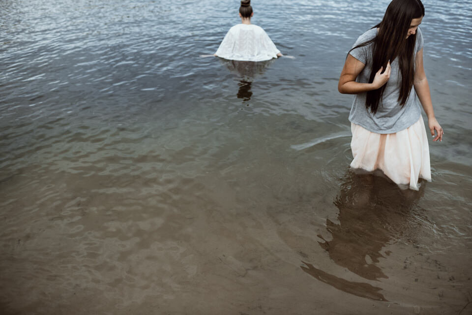 girls standing in blue water