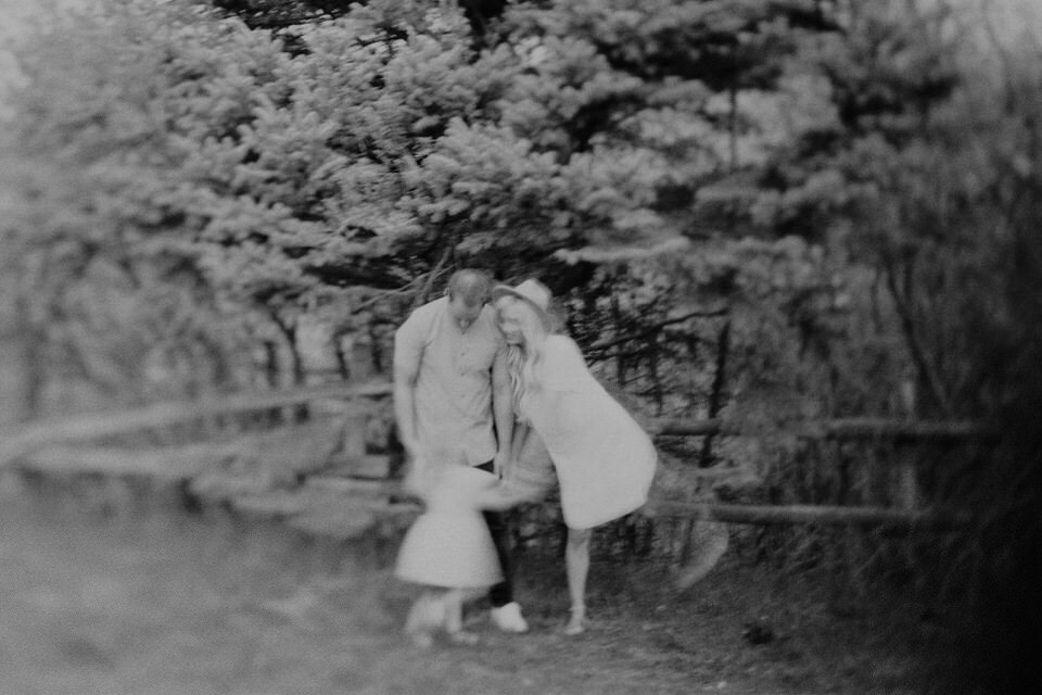 black and white film photo of family of four with motion blur