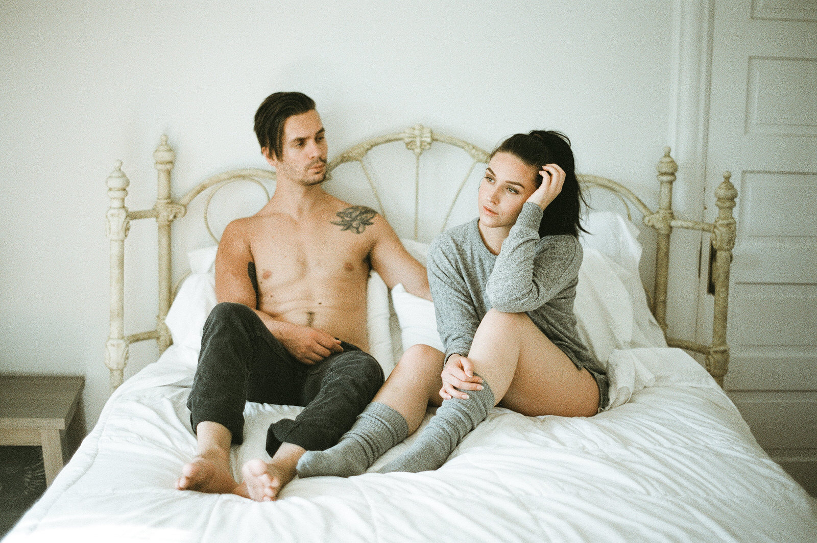 couple snuggling in bed with white sheets