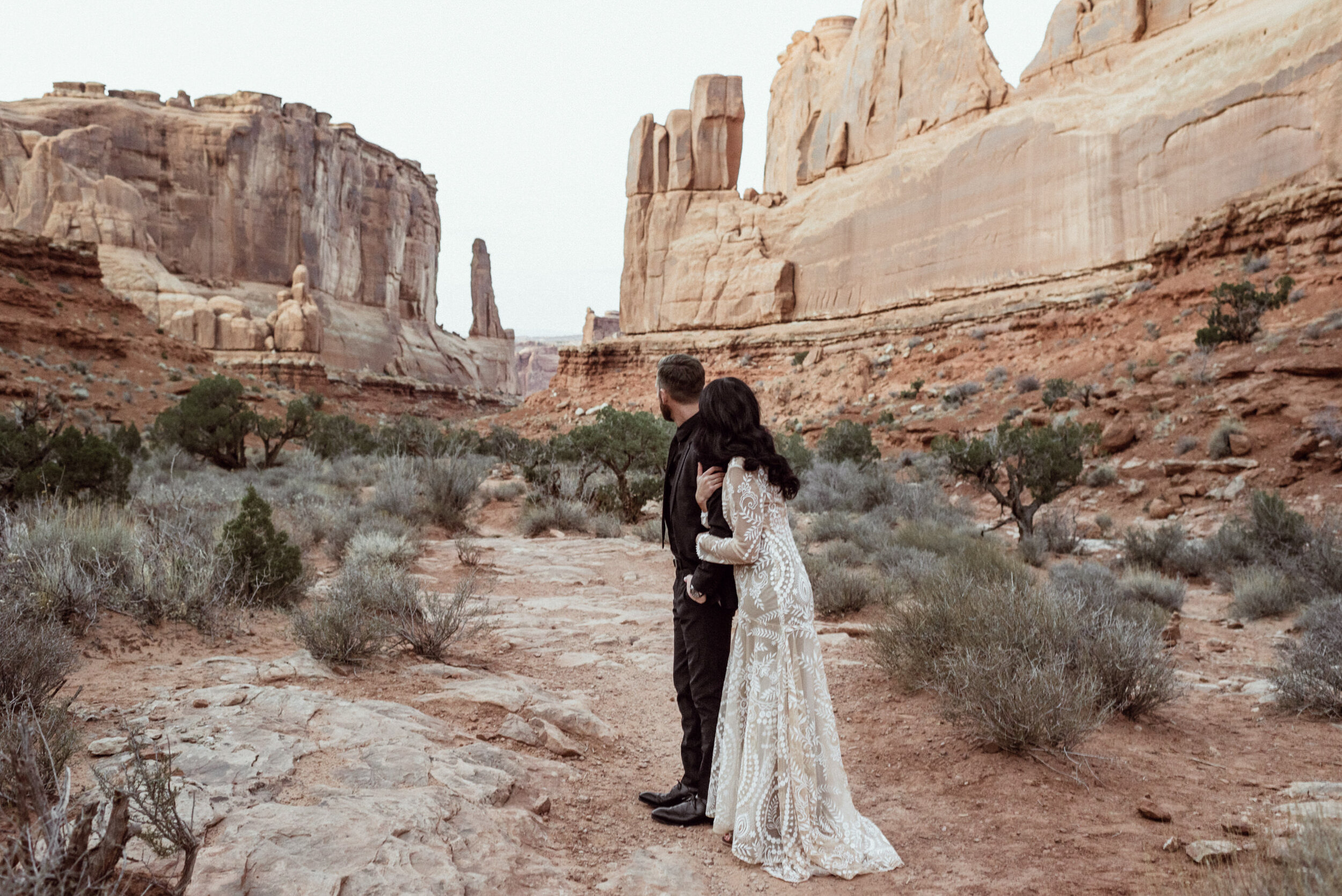 wedding couple looking at sandstone canyon view