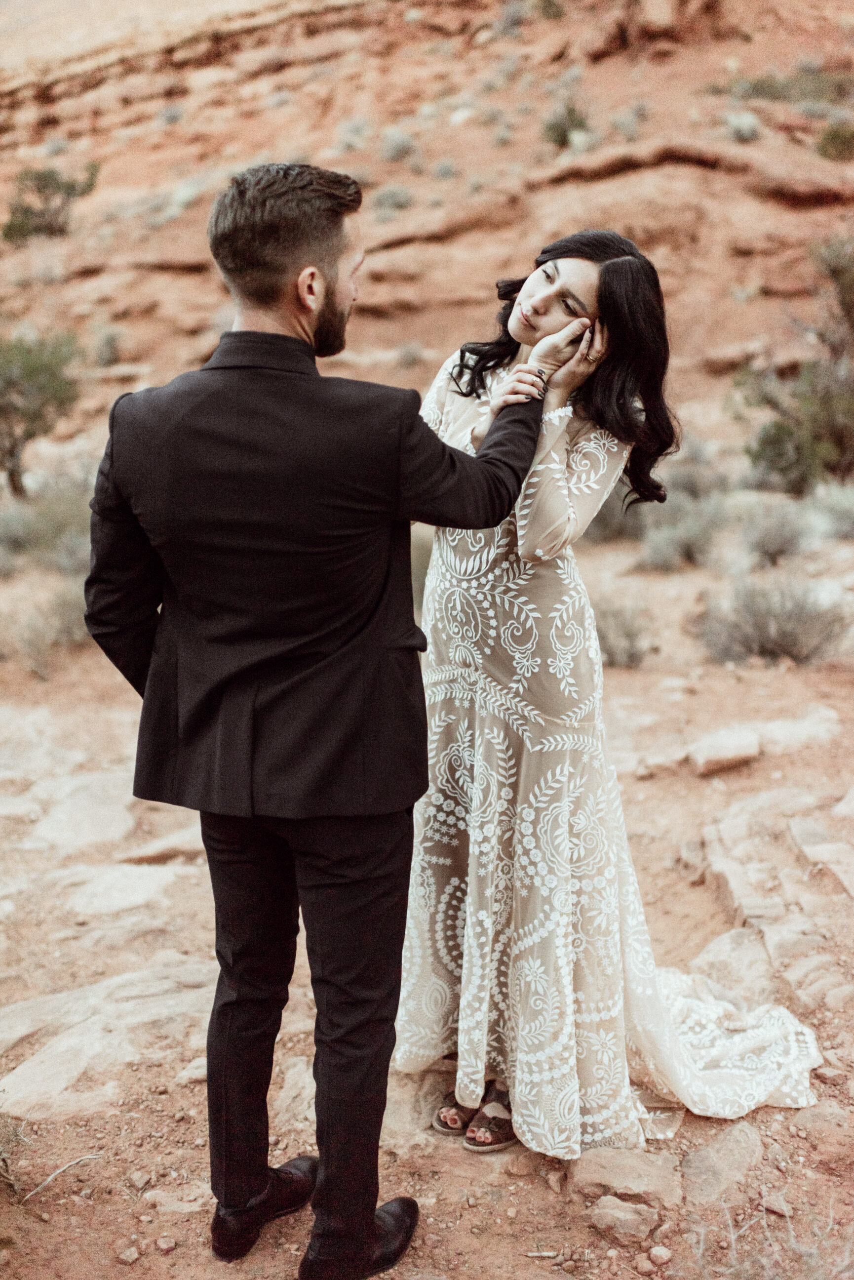bride leaning into groom's hand in sandstone canyon