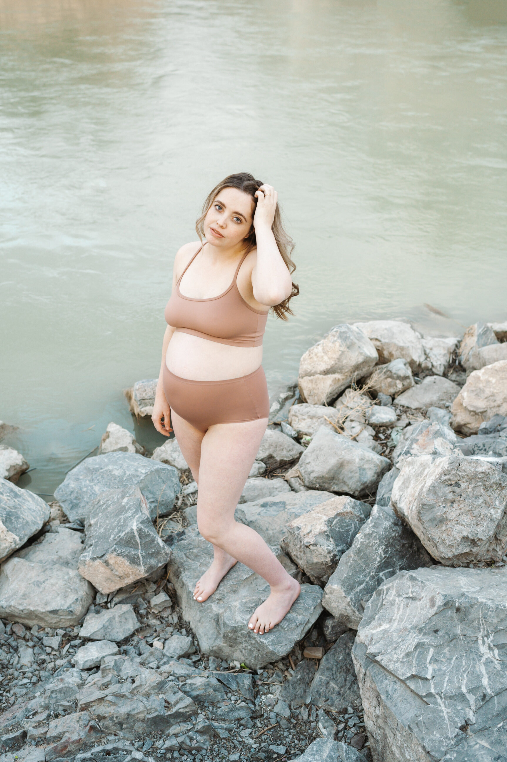 pregnant mom standing in front of river
