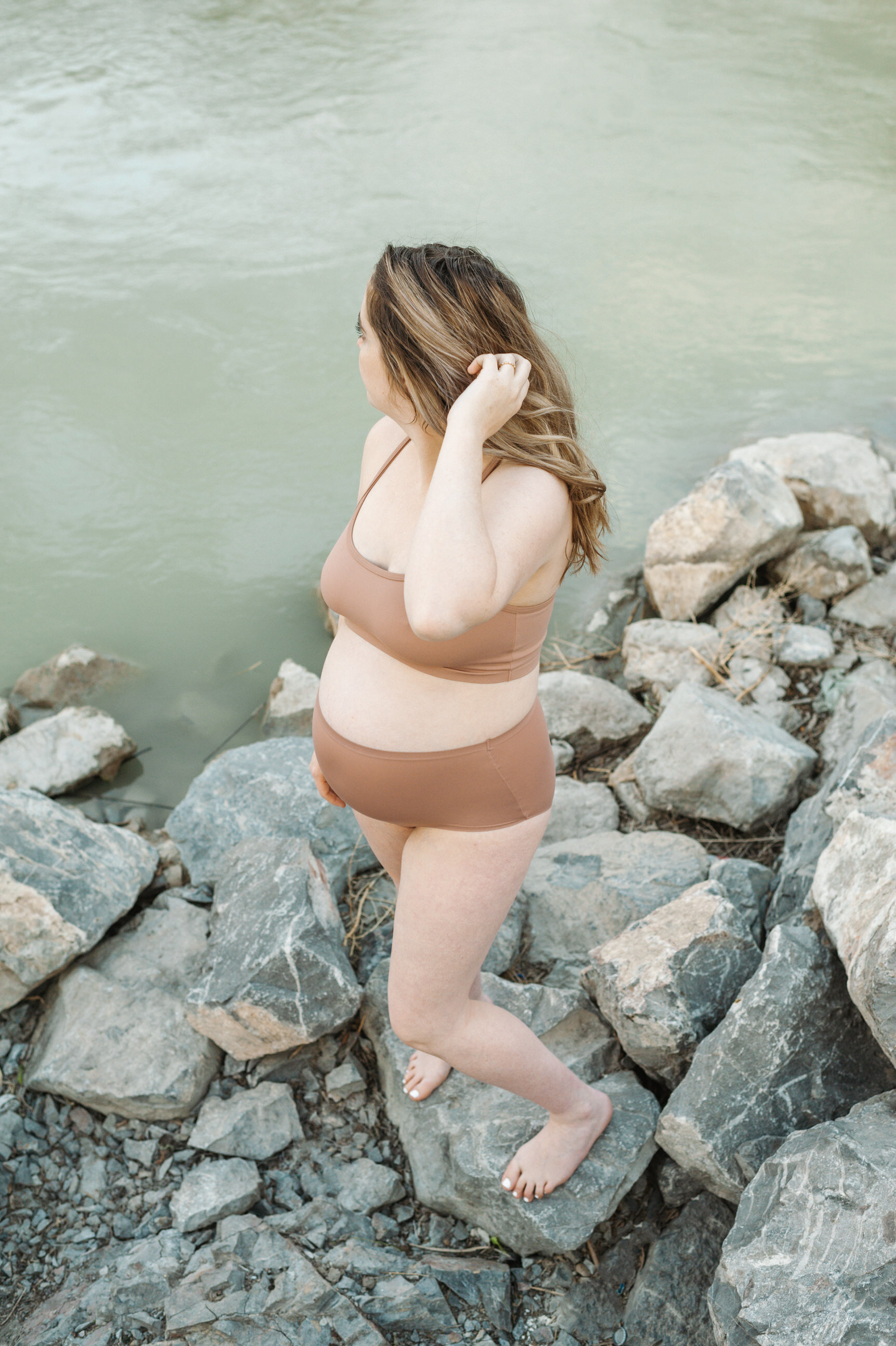 pregnant mom standing in front of river
