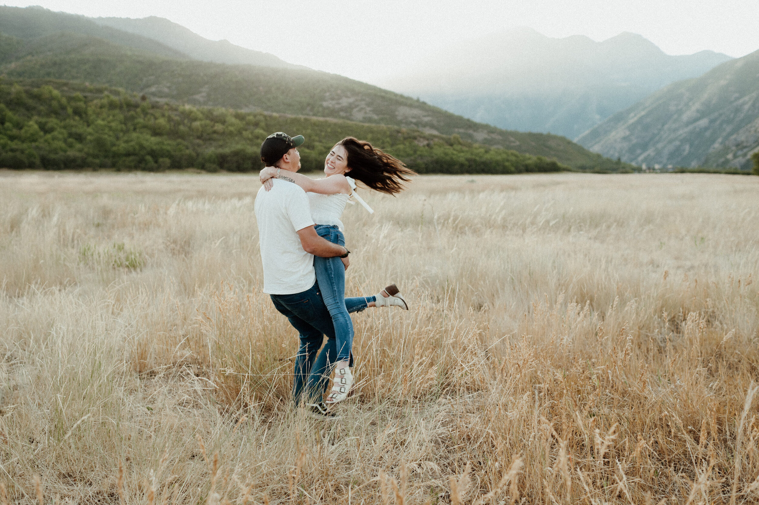 couple spinning around in golden field in the utah mountains