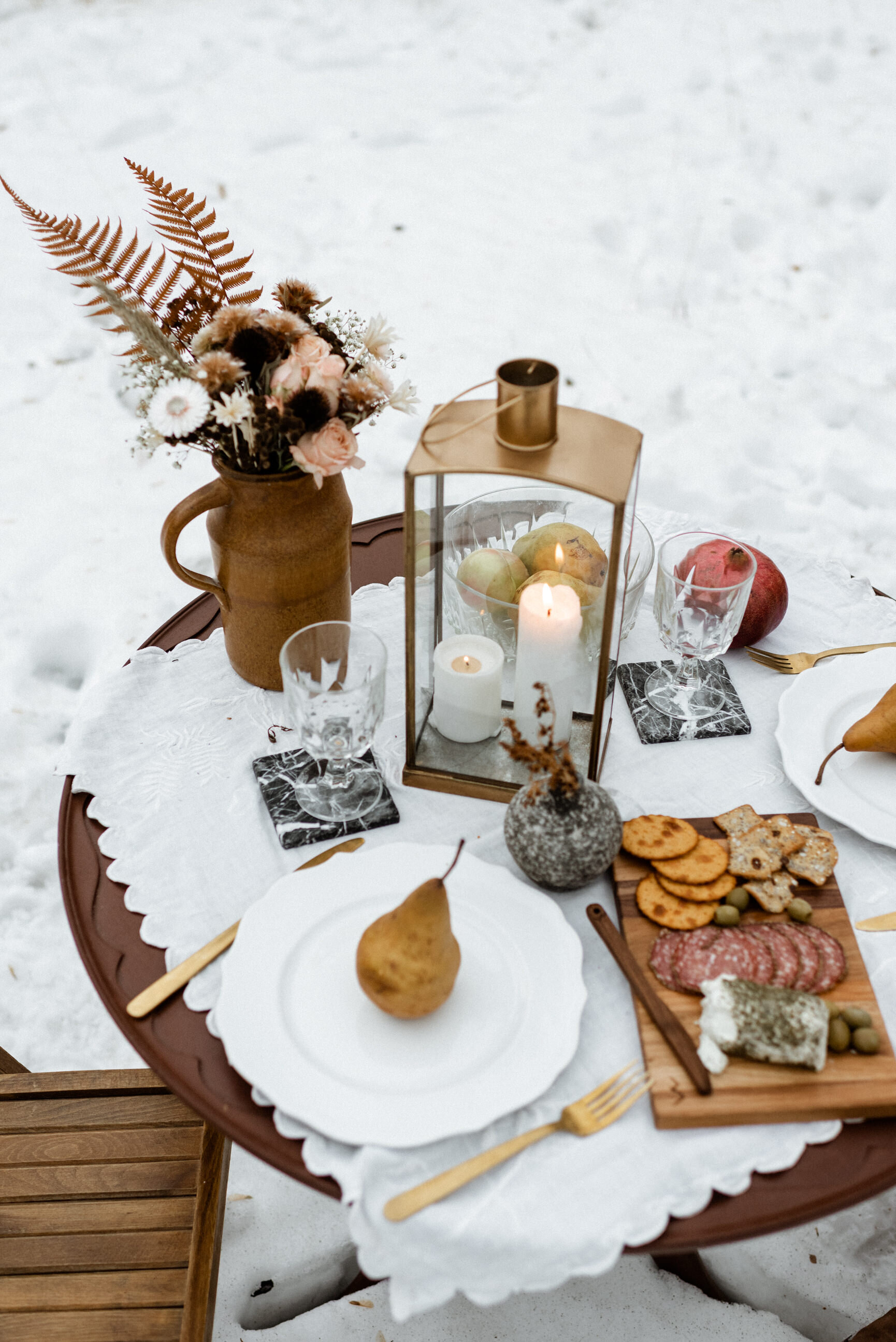 picnic table with pear, pomegranate, charcuterie board, gold cutlery